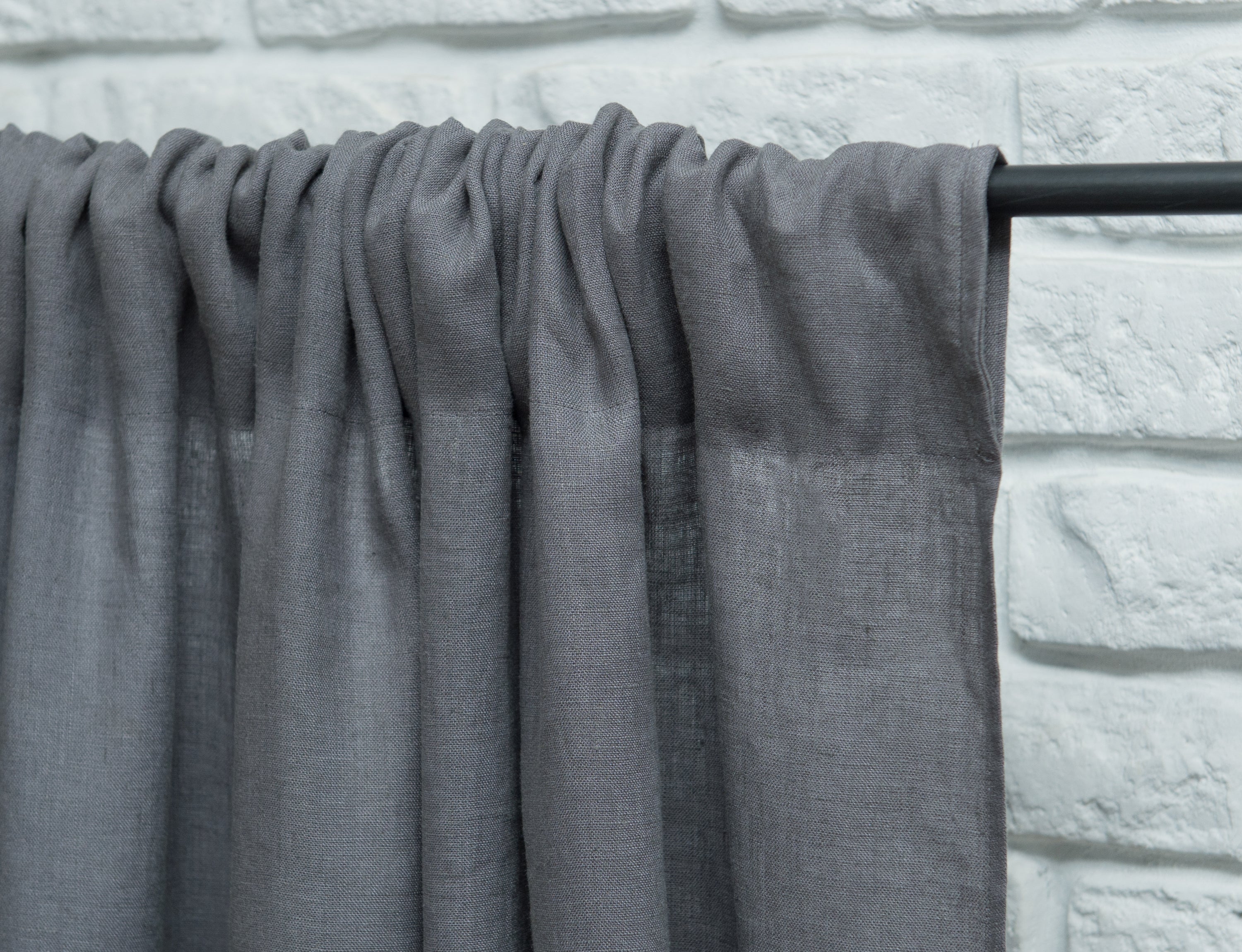 Light Grey linen curtain with ruffles and rod pocket, elegantly draped to showcase its texture and design.