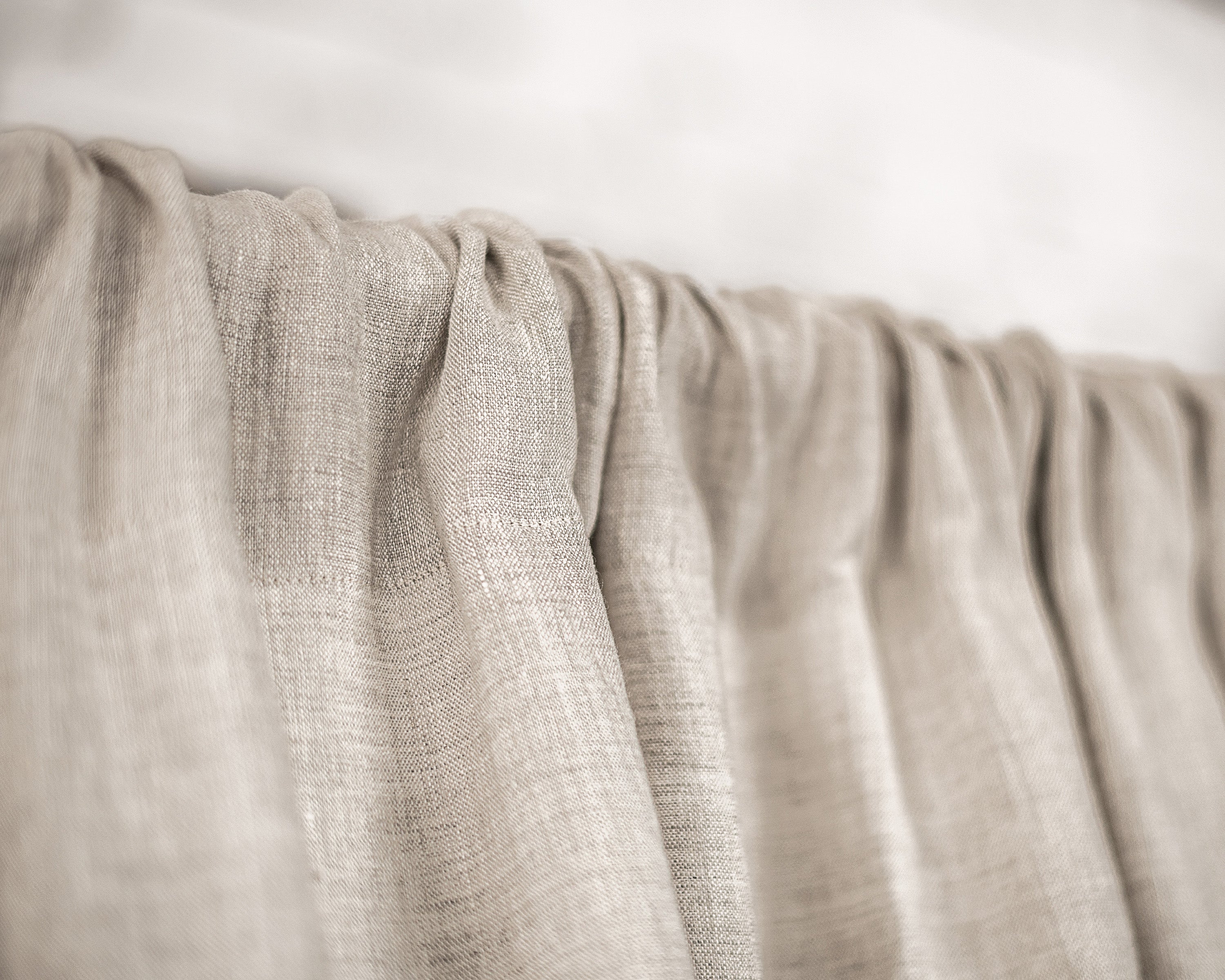 Light Grey linen curtain with ruffles and rod pocket, elegantly draped to showcase its texture and design.