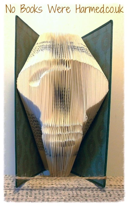 Hand-folded lightbulb art made from vintage book pages, showcasing intricate folds and unique colors.