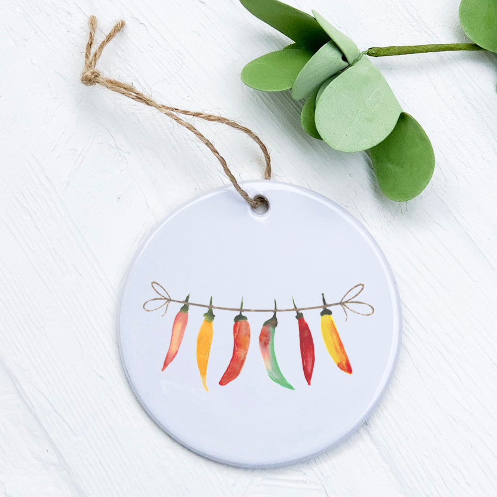 A beautifully designed porcelain ornament featuring a Line of Peppers, showcasing vibrant colors and a glossy finish.