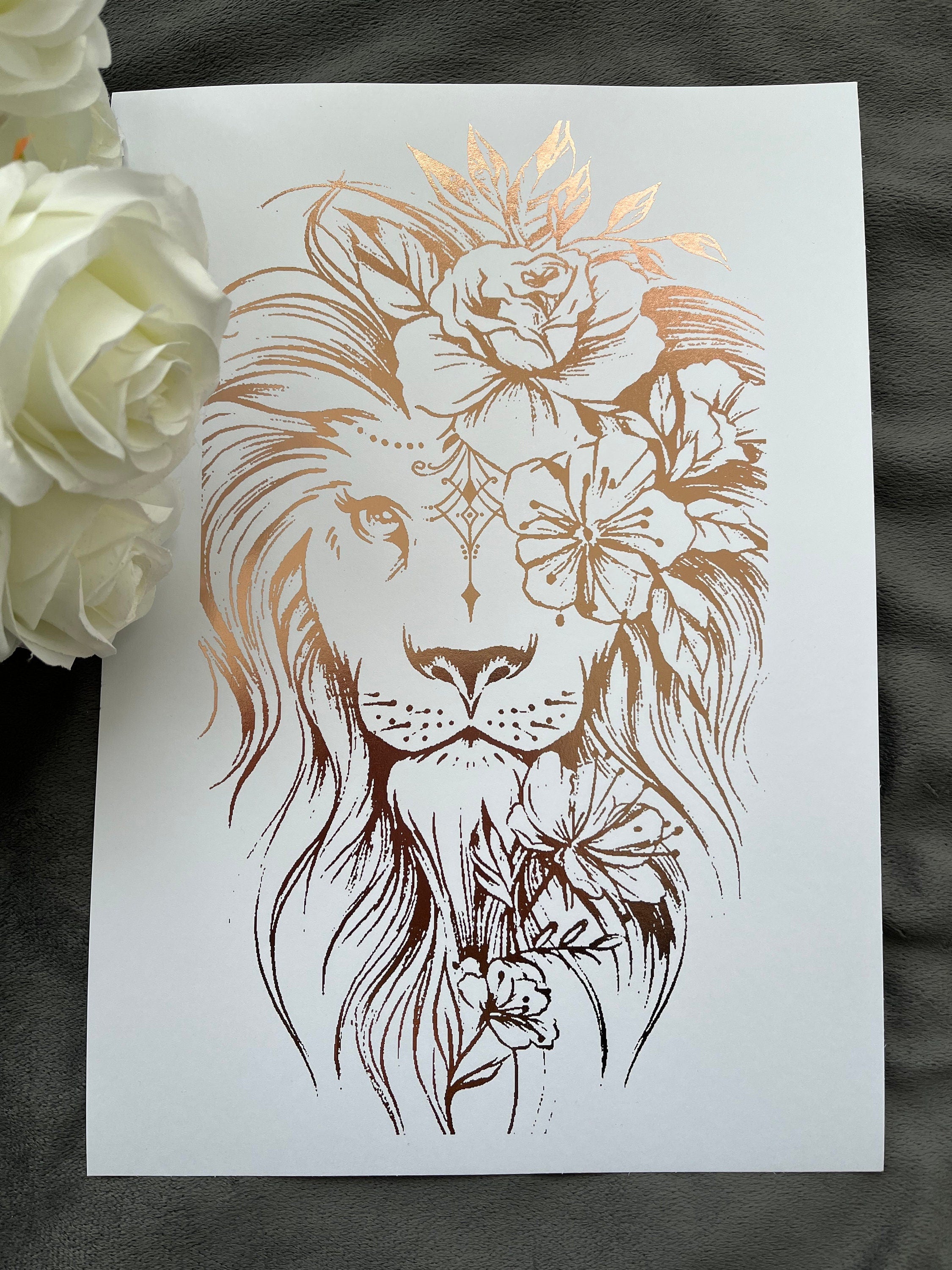 A stunning lion foil print featuring a rose gold lion on a white background, symbolizing courage and strength.