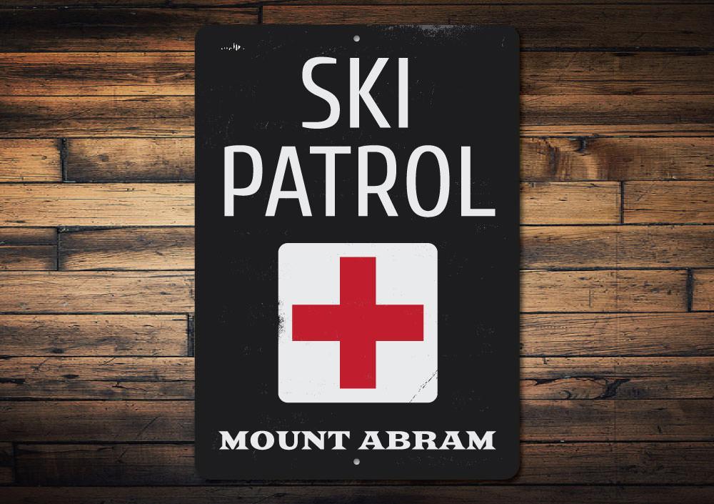 A decorative Location Ski Patrol Sign made of high-quality aluminum, featuring customizable text and pre-drilled holes for easy mounting.