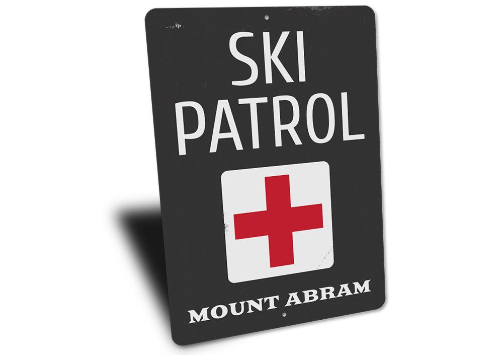 A decorative Location Ski Patrol Sign made of high-quality aluminum, featuring customizable text and pre-drilled holes for easy mounting.