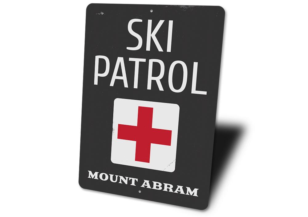 A decorative Location Ski Patrol Sign made of high-quality aluminum, featuring customizable text and pre-drilled holes for easy mounting.