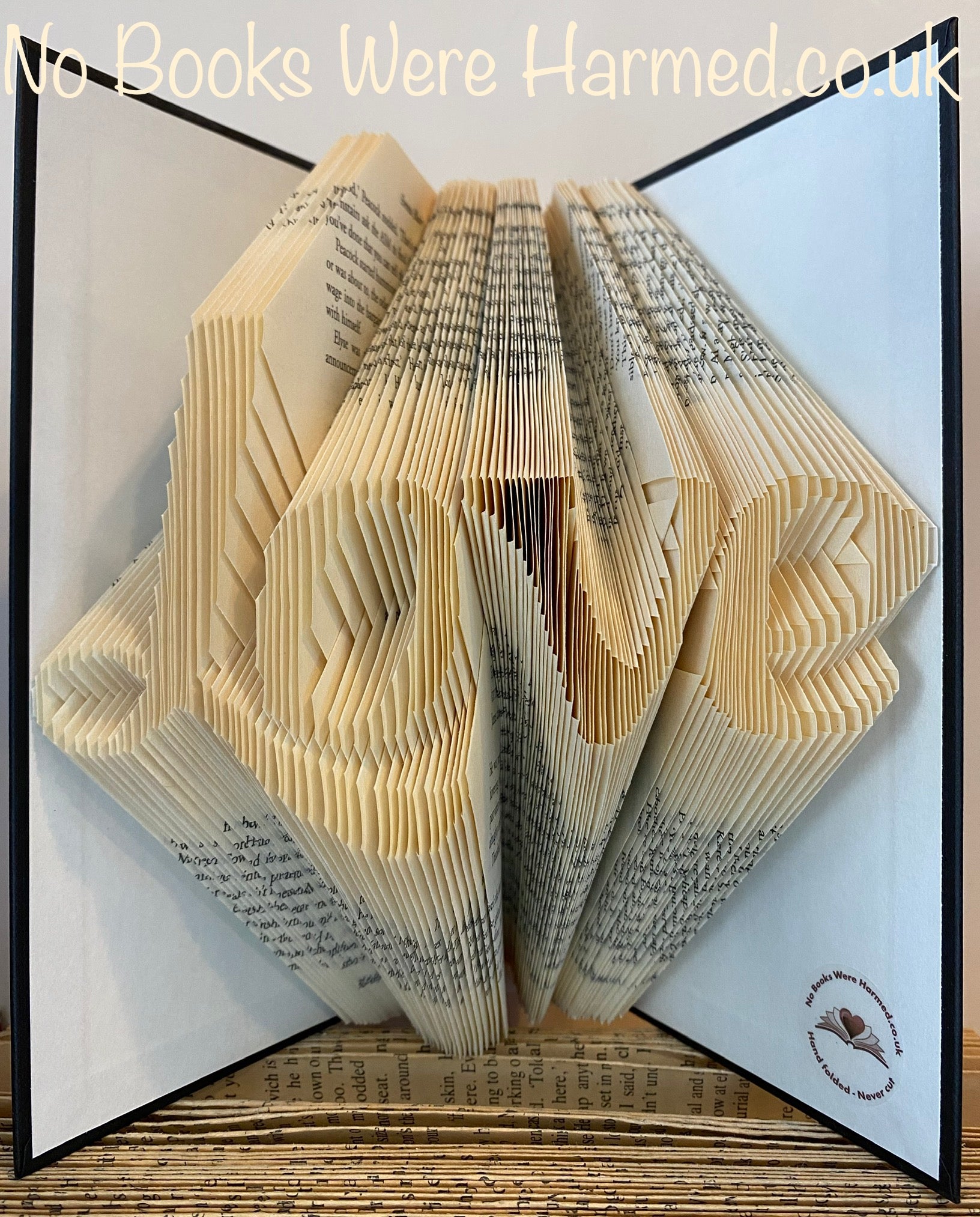 Handcrafted 'Love' fancy L art piece made from vintage book pages, showcasing intricate folds and unique design.