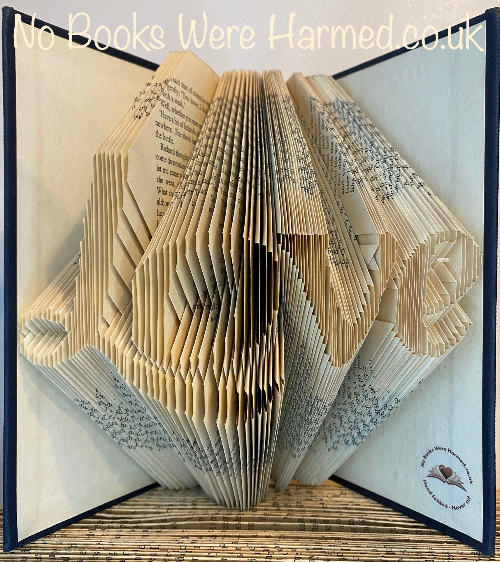 Handcrafted 'Love' fancy L art piece made from vintage book pages, showcasing intricate folds and unique design.