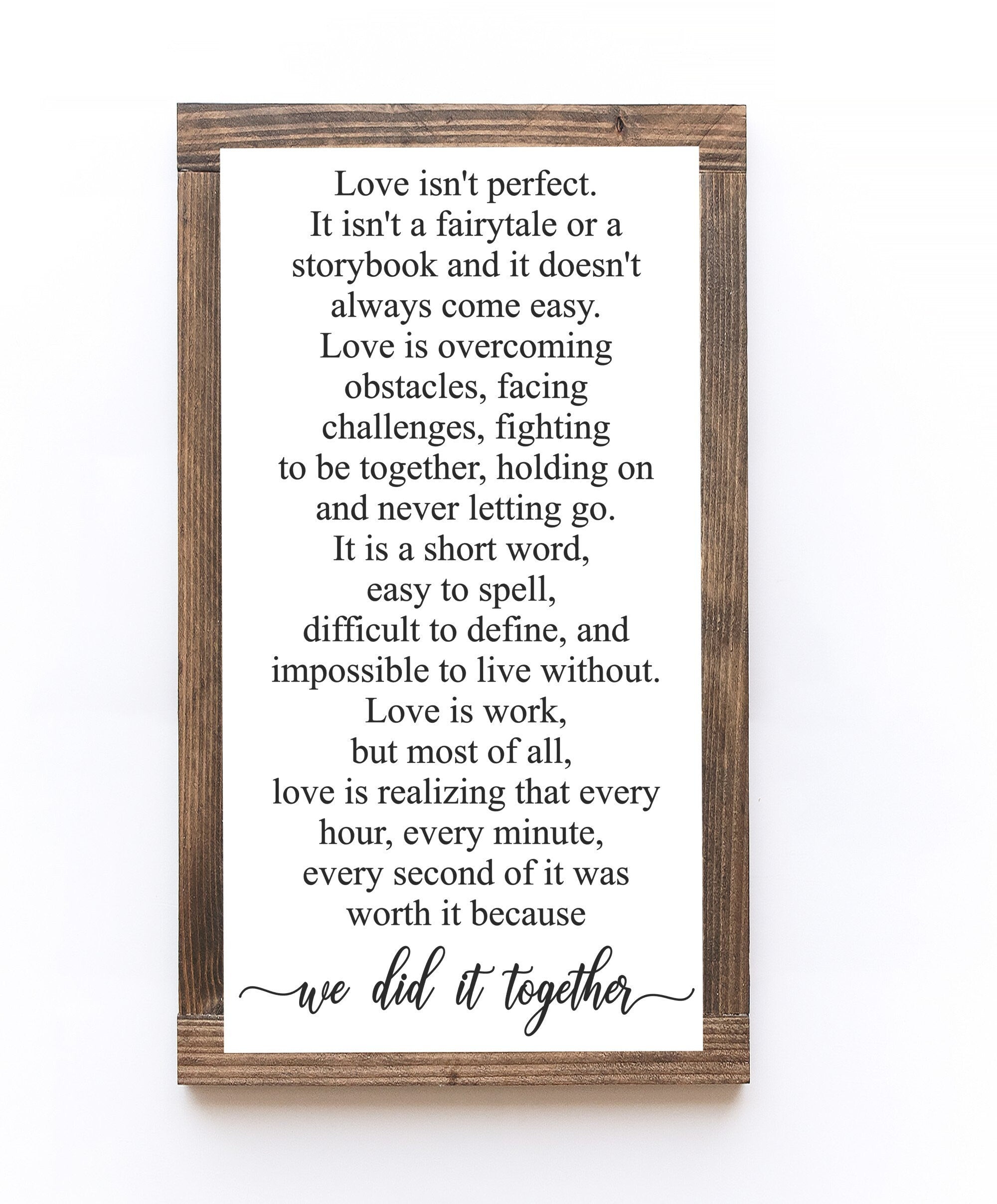 Handmade wooden sign with the phrase 'Love Isn't Perfect It's Overcoming Obstacles' in matte white finish, showcasing unique wood grain.