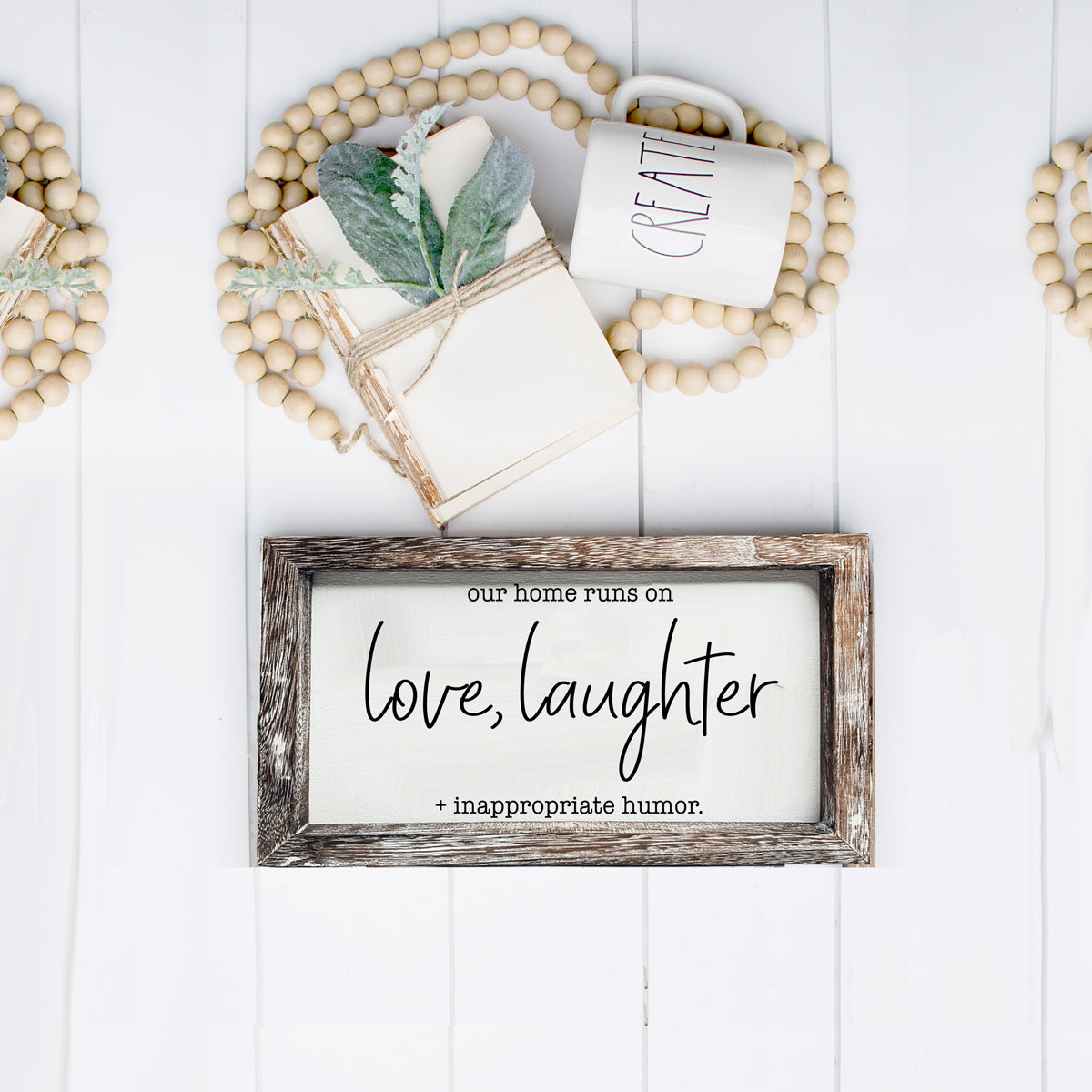 A vintage-style wooden sign that reads 'Our Home Runs on Love, Laughter + Inappropriate Humor', made from durable Paulownia wood.