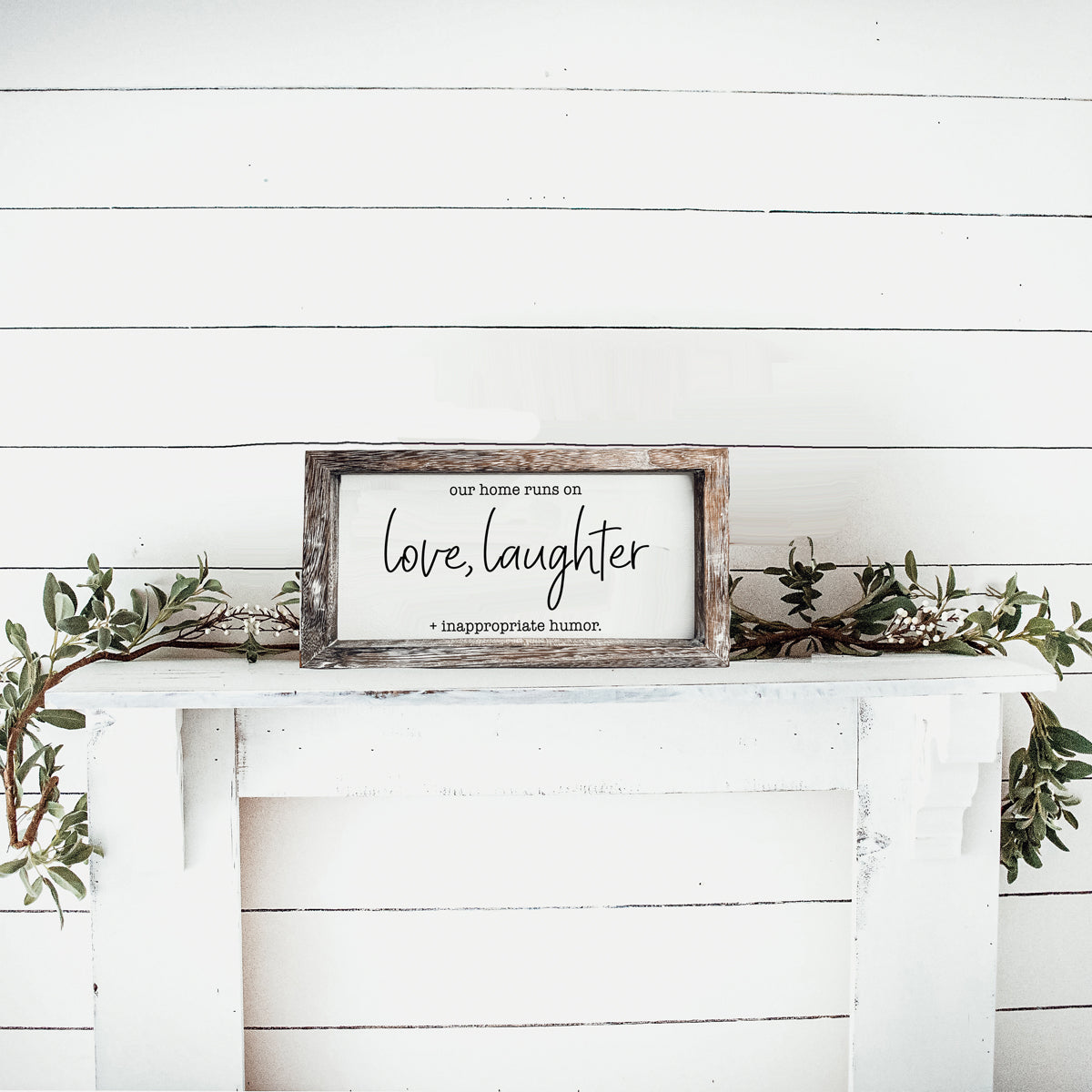 A vintage-style wooden sign that reads 'Our Home Runs on Love, Laughter + Inappropriate Humor', made from durable Paulownia wood.