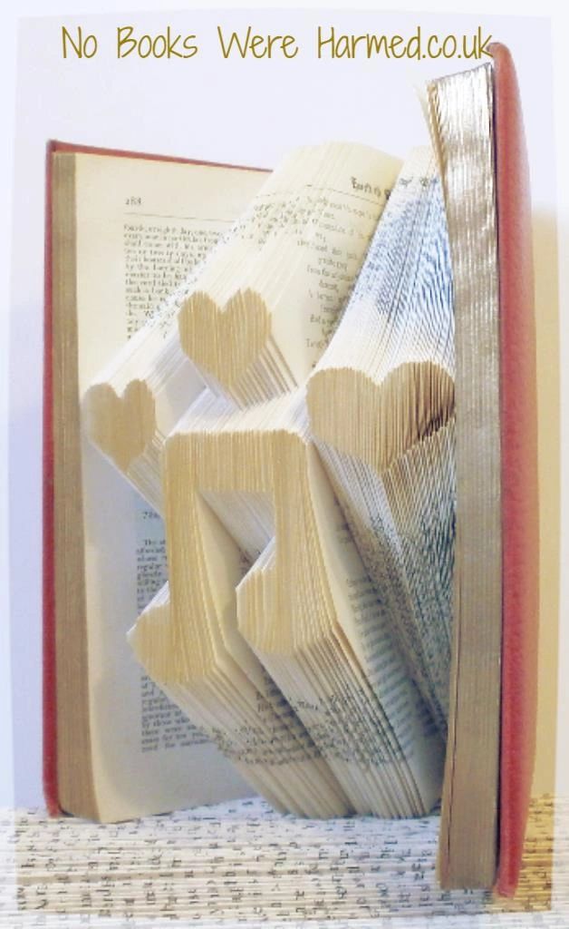 Hand-folded Love Music book art made from vintage book pages, showcasing intricate designs and unique colors.