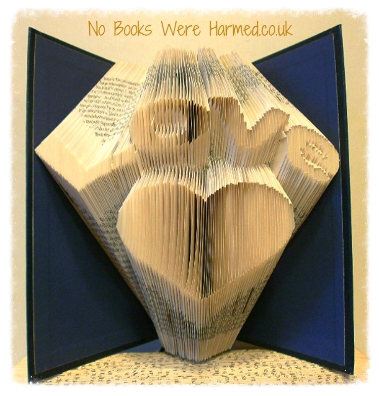 Handcrafted 'Love' heart art made from vintage book pages, showcasing intricate folds and unique colors.