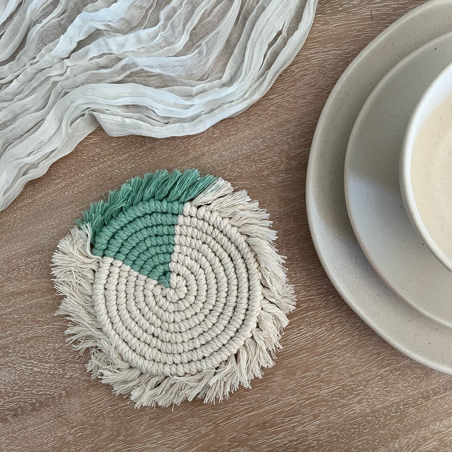 Handwoven macramé drink coaster, 7 inches in diameter, made of cotton cord, showcasing intricate patterns and natural texture.