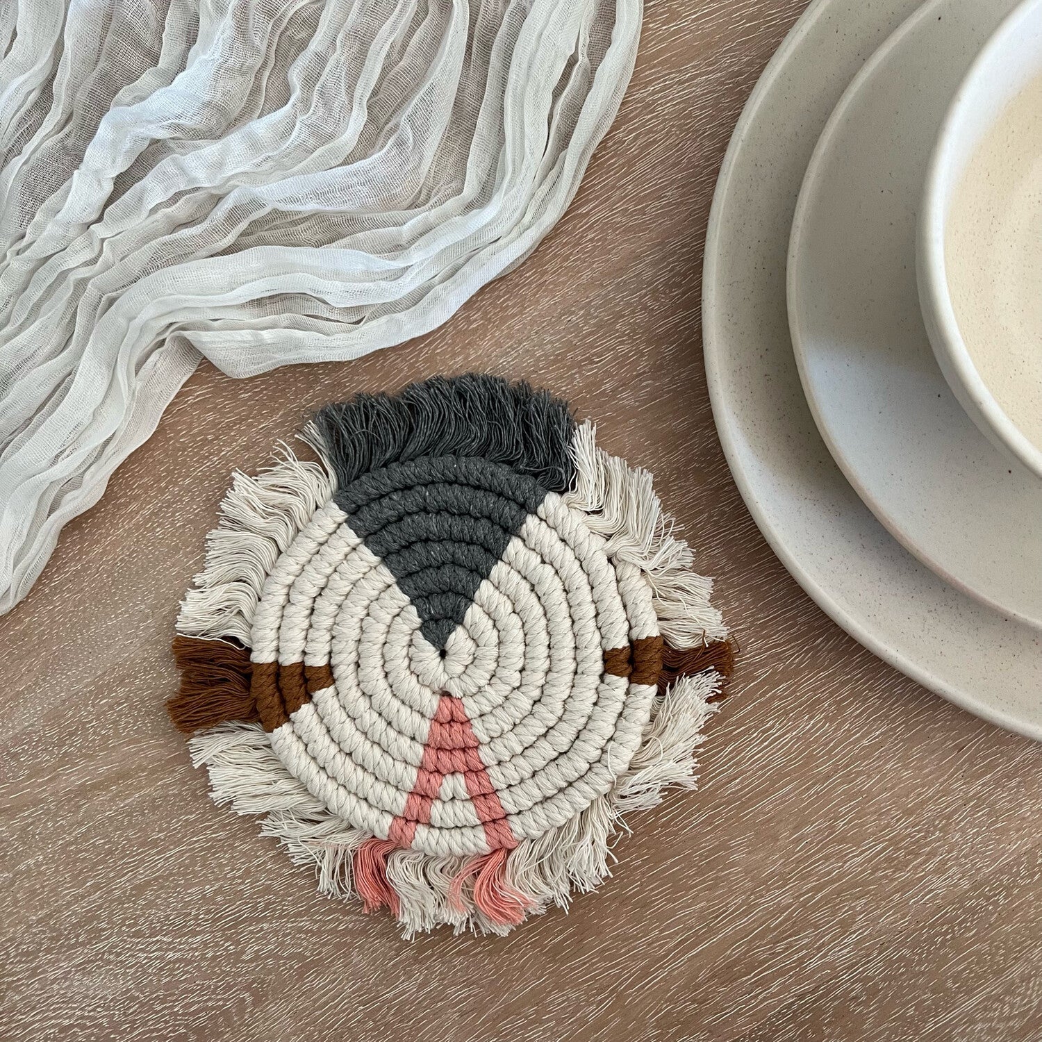 Handwoven macramé drink coaster, 7 inches in diameter, made of cotton cord, showcasing intricate patterns and natural texture.