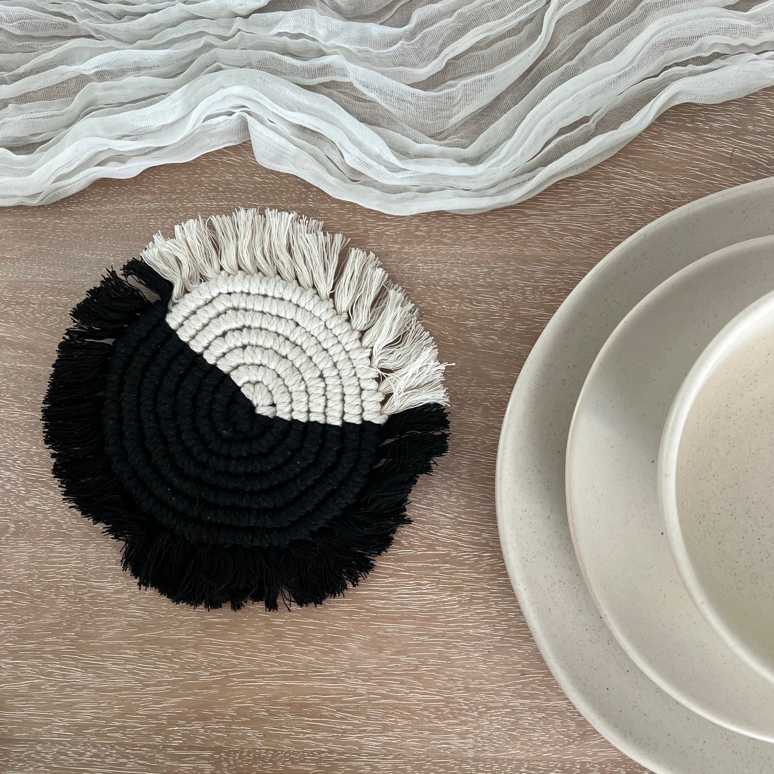 Handwoven macramé drink coaster, 7 inches in diameter, made of cotton cord, showcasing intricate patterns and natural texture.