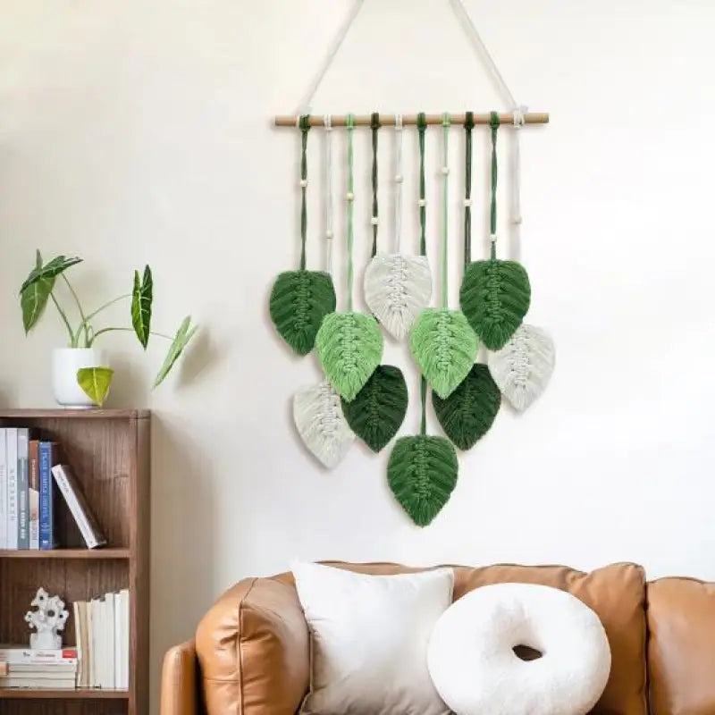 A beautifully handcrafted macrame wall hanging featuring a leaf design, made from soft green cotton rope, perfect for home decor.