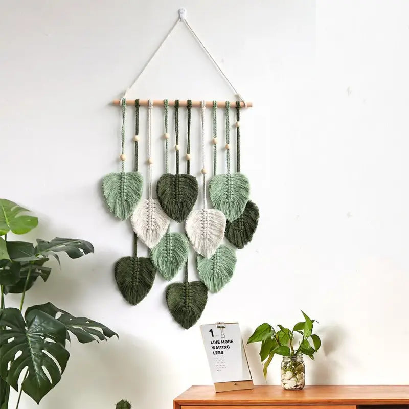 A beautifully handcrafted macrame wall hanging featuring a leaf design, made from soft green cotton rope, perfect for home decor.