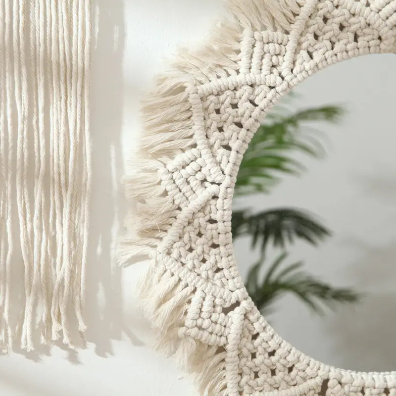 A beautifully crafted round macrame wall mirror wrapped in soft cotton rope, showcasing intricate details and a boho style.