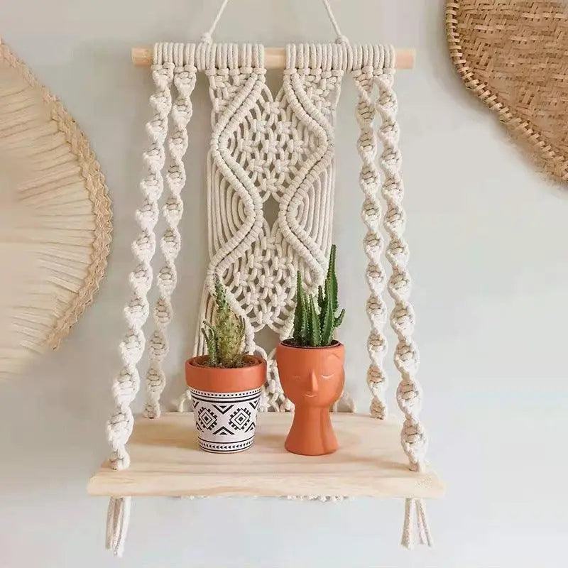 A beautifully handcrafted Macrame Wall Tapestry Plant Holder made from cotton cords, featuring a natural wooden shelf for plants or books.