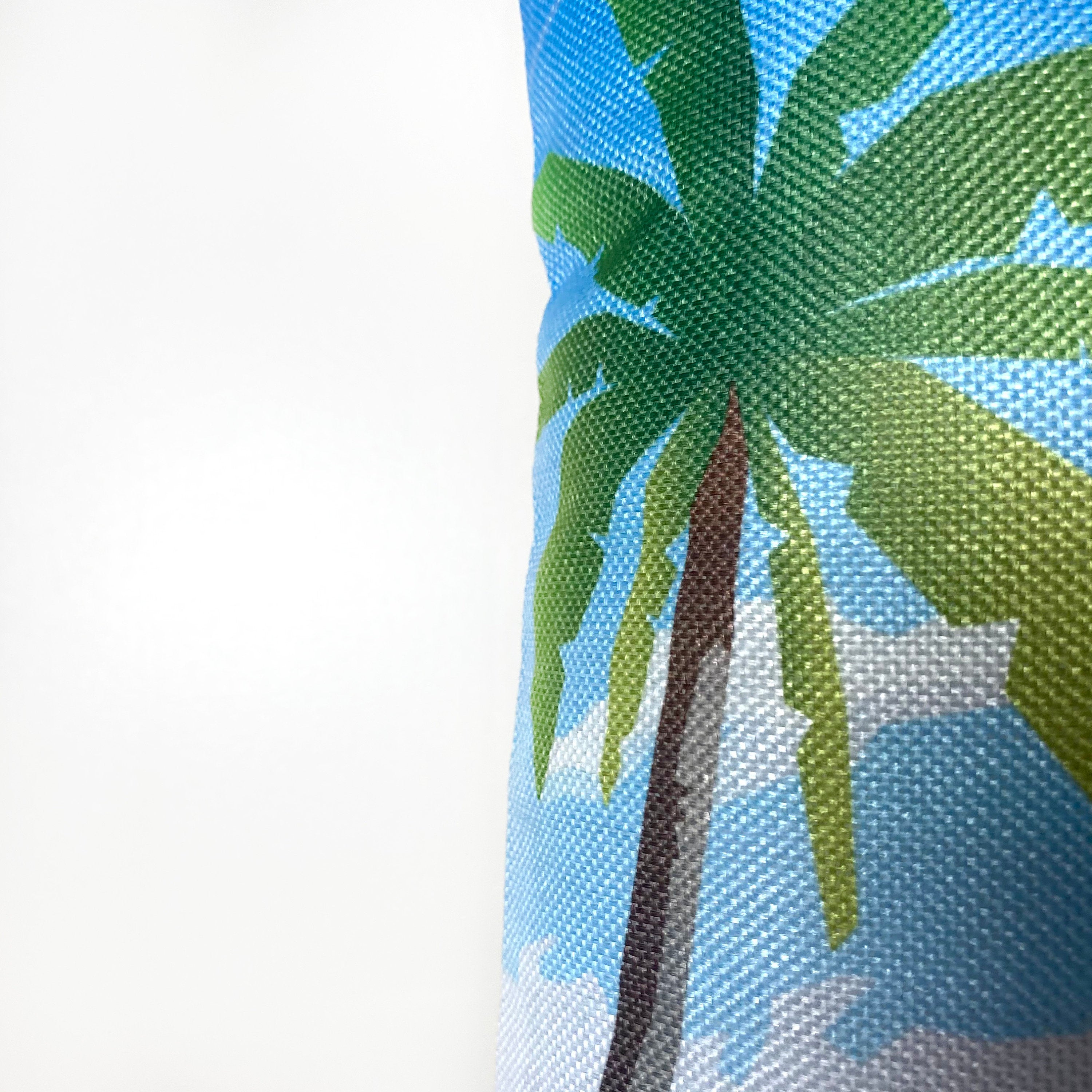 A vibrant 12x18 pillow cover featuring a travel poster of a beach in the Maldives, showcasing tropical colors and a concealed zipper.