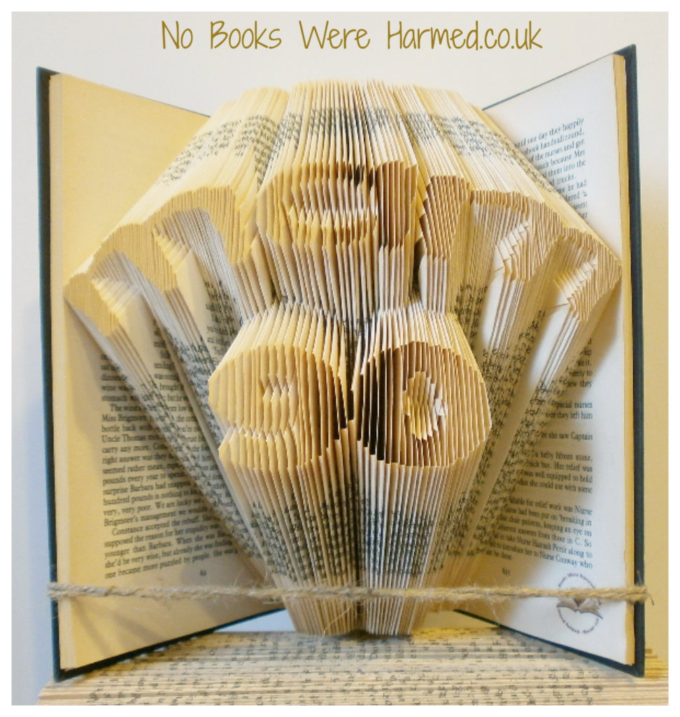 Hand-folded book art featuring the word 'Mam' over a number, crafted from vintage books.