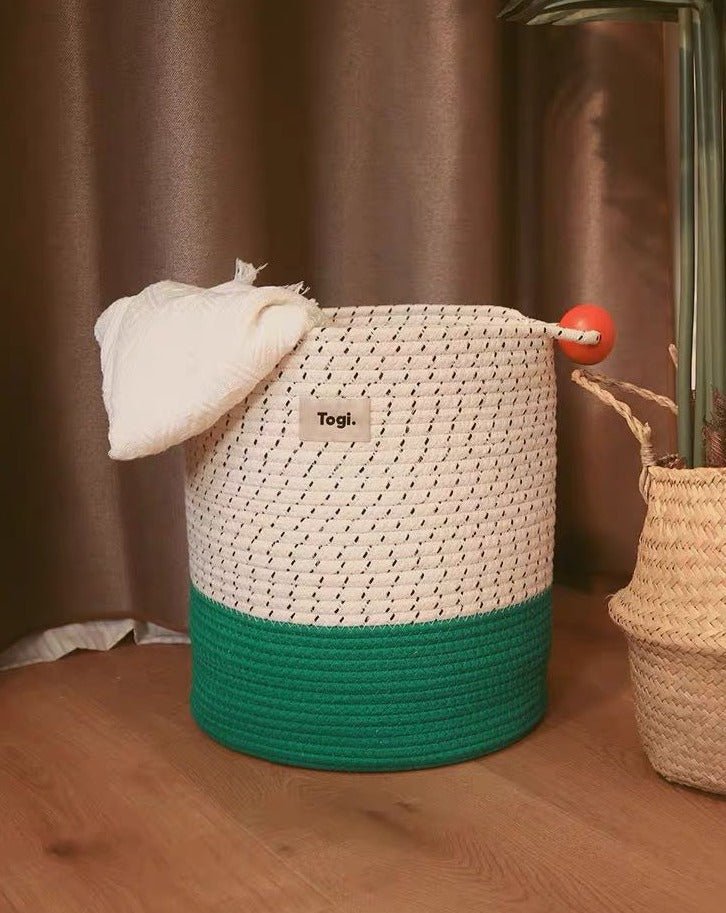 Colorful handmade woven laundry storage basket with comfortable handles, showcasing maximalism design.