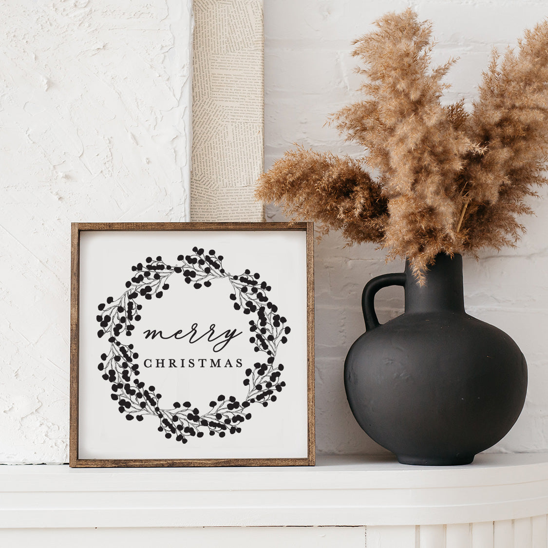 Merry Christmas Wood Sign featuring a detailed wreath design, available in black and white, framed in espresso stained pine.