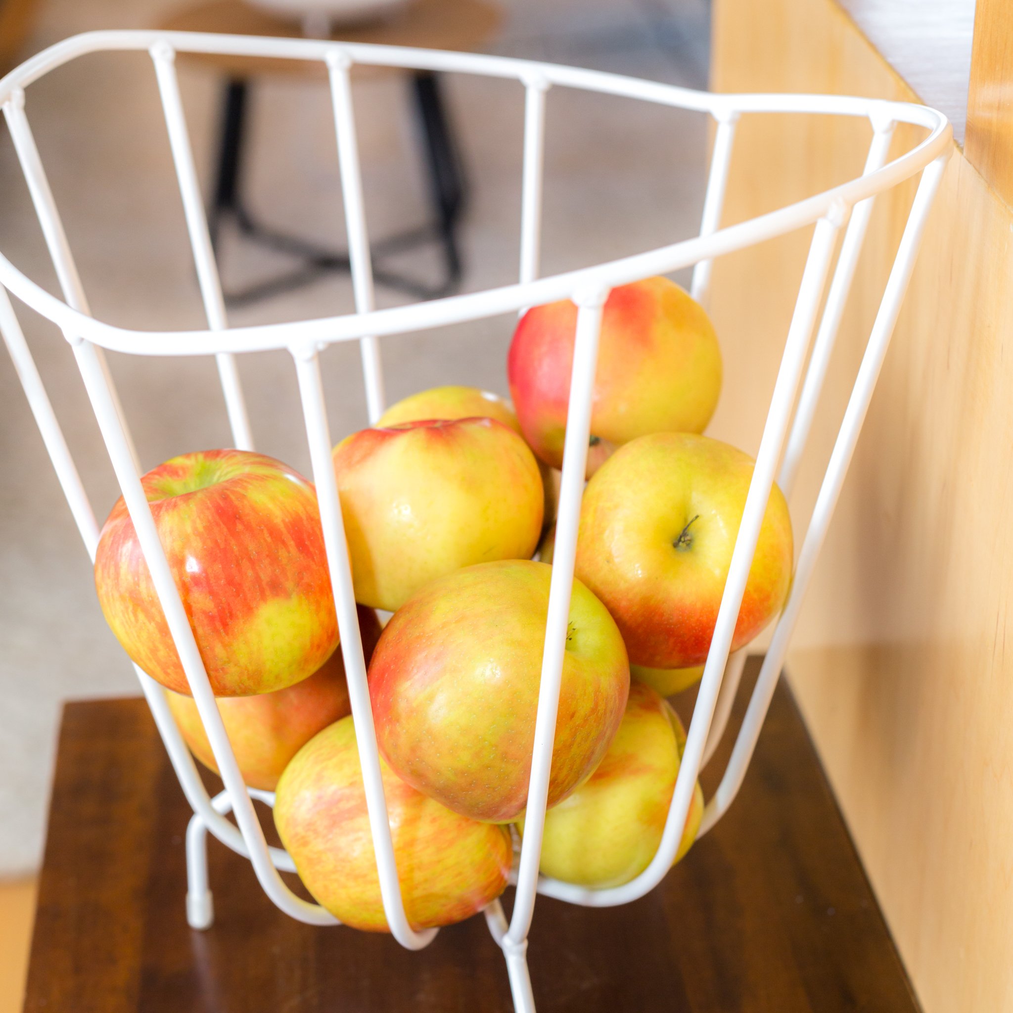 A modern handmade metal basket by K'WILLEM IN HUIS, crafted from recycled round iron with a powder-coated finish, showcasing its stylish design and multiple color options.