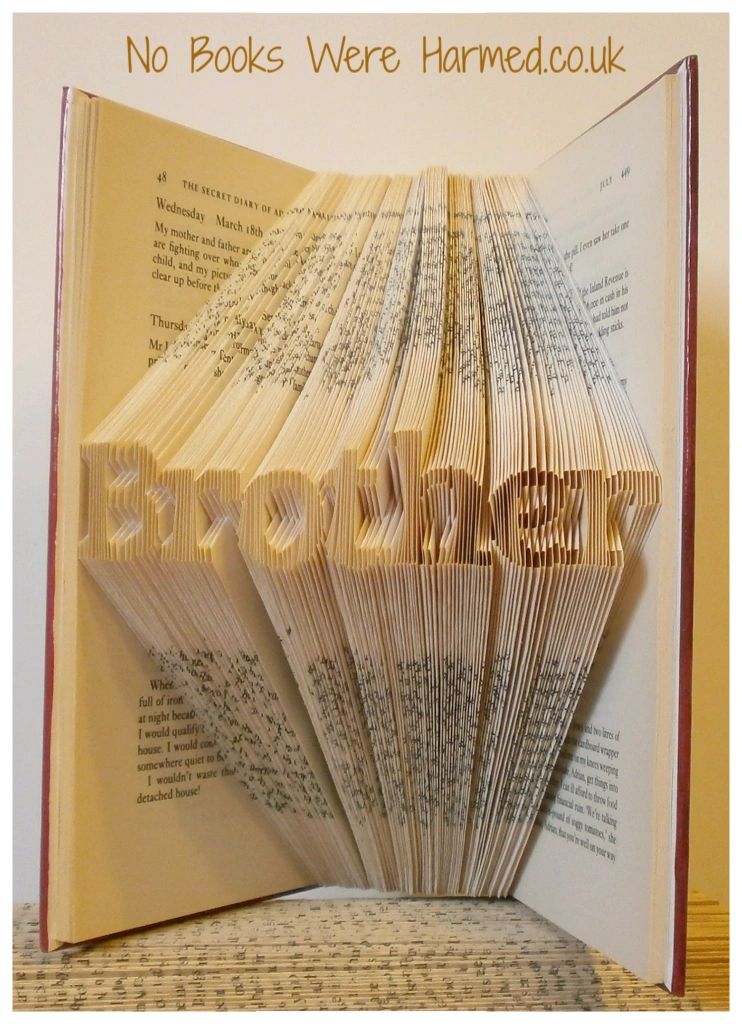 Mini 'Brother' art piece handcrafted from vintage books, showcasing intricate hand-folded pages.