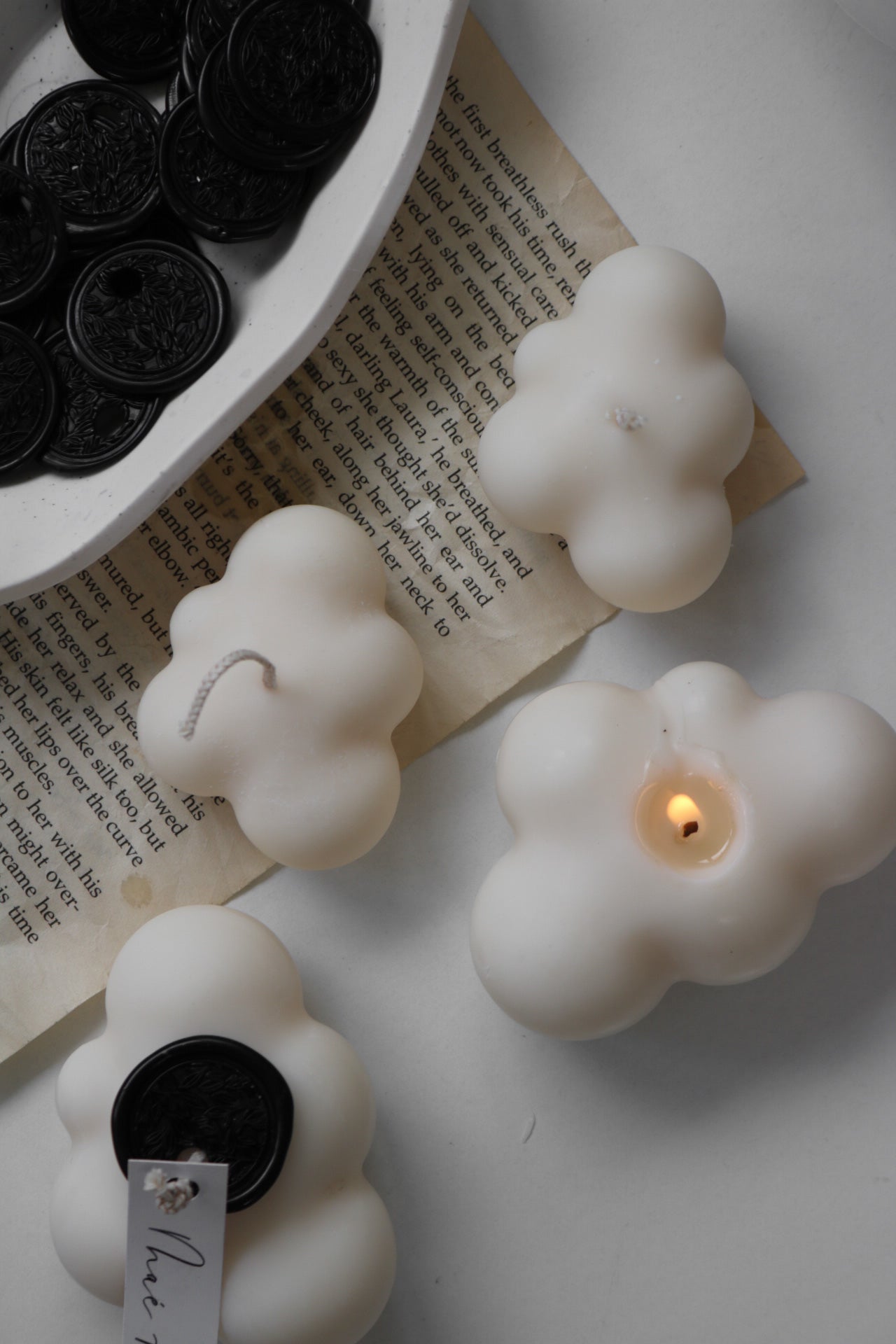 A decorative Mini Cloud candle in soft cream and white, hand poured from a soy wax blend, showcasing its sculptural design.