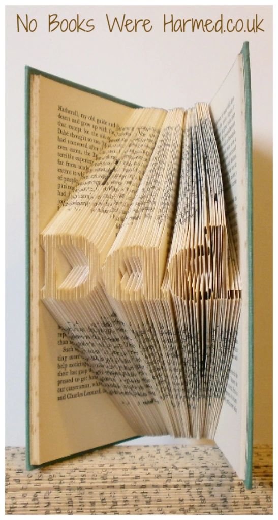 Mini 'Dad' art piece handcrafted from vintage book pages, showcasing intricate folds and unique design.