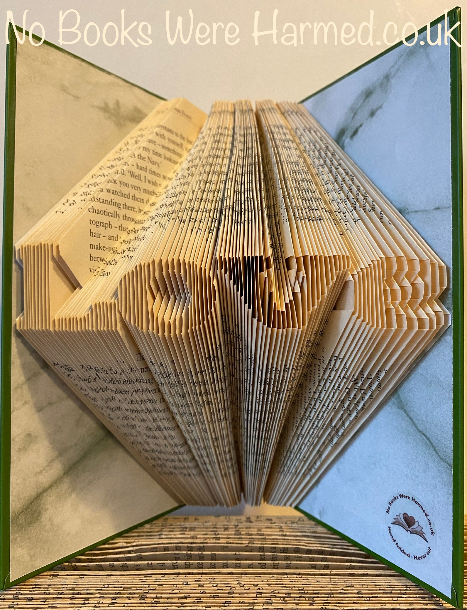 A handcrafted mini 'Love' art piece made from vintage book pages, showcasing intricate folds and unique design.