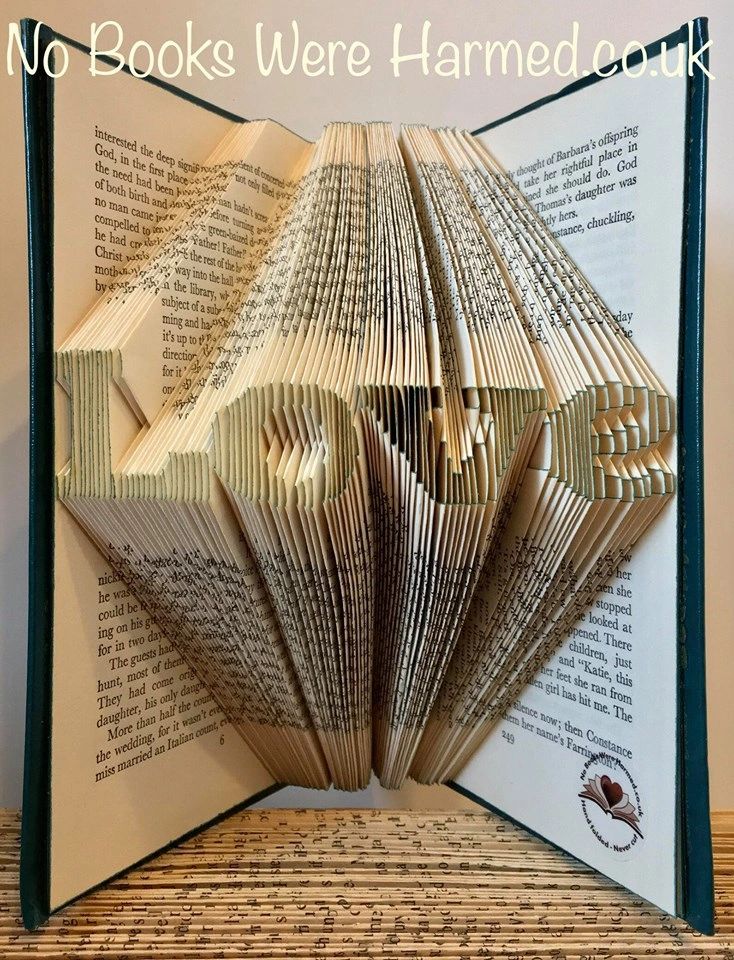 A handcrafted mini 'Love' art piece made from vintage book pages, showcasing intricate folds and unique design.