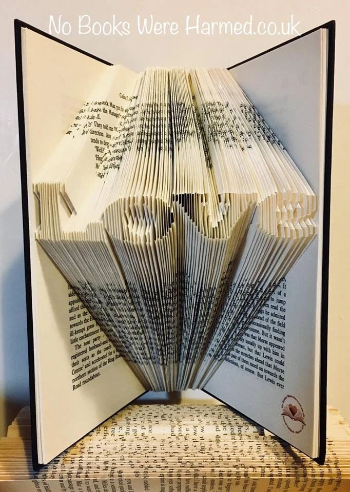 A handcrafted mini 'Love' art piece made from vintage book pages, showcasing intricate folds and unique design.