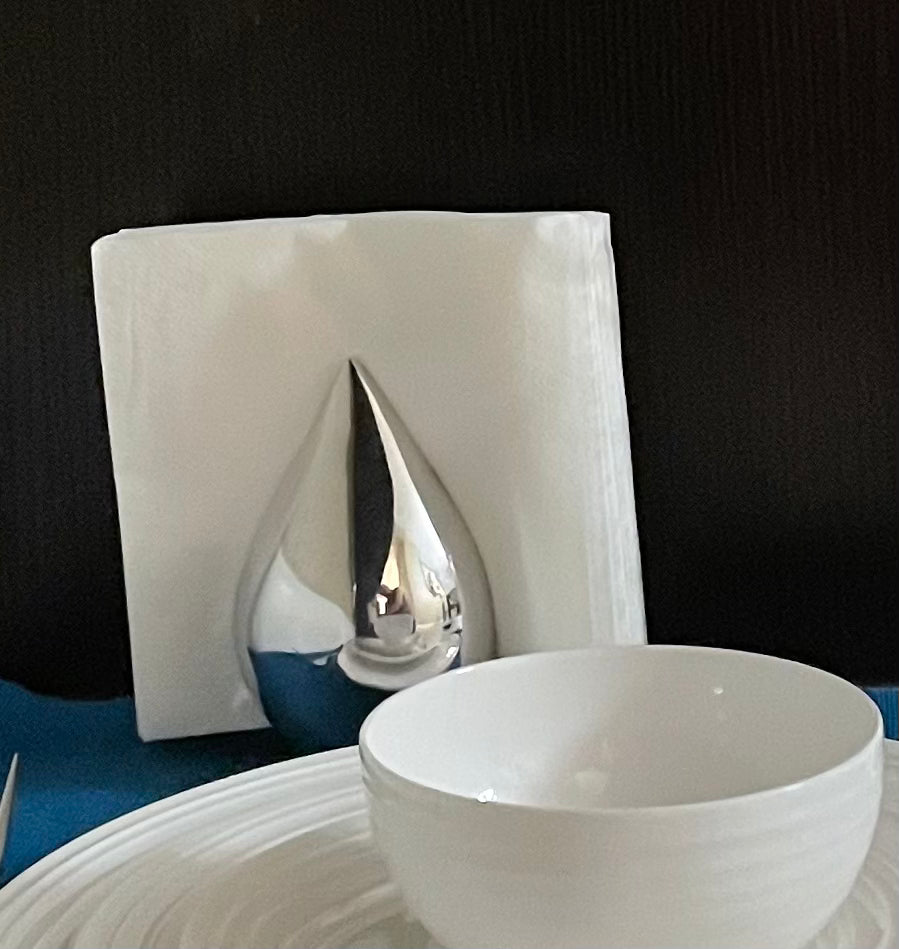 A sleek and elegant Minimalist FreeStanding Napkin Holder made from recycled aluminum, featuring a wavy elongated shape and a chic finish.