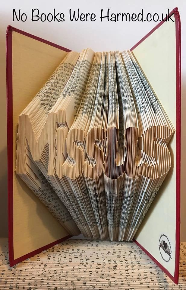 A unique piece of hand-folded book art from the Missus collection, showcasing intricate folds and vibrant colors from vintage book pages.