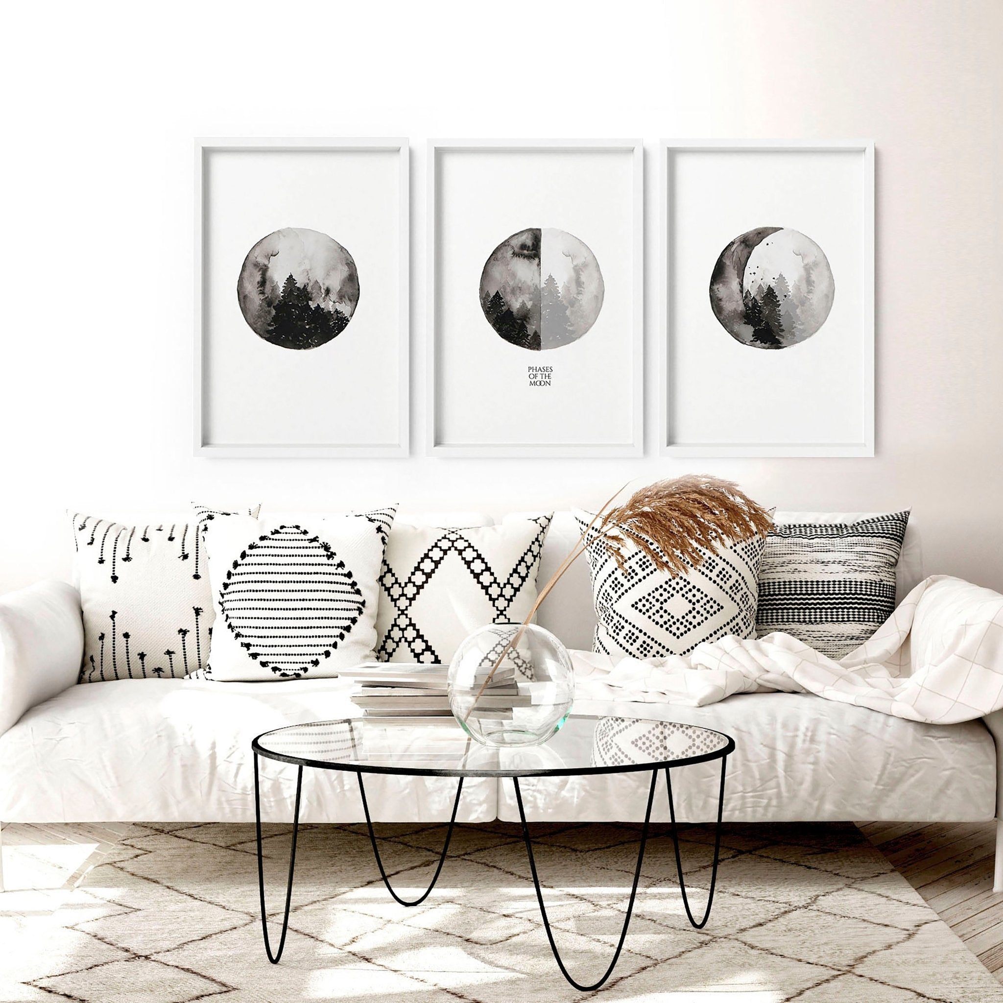 Set of 3 framed wall art prints depicting the phases of the moon in a monochromatic design, perfect for enhancing living room decor.