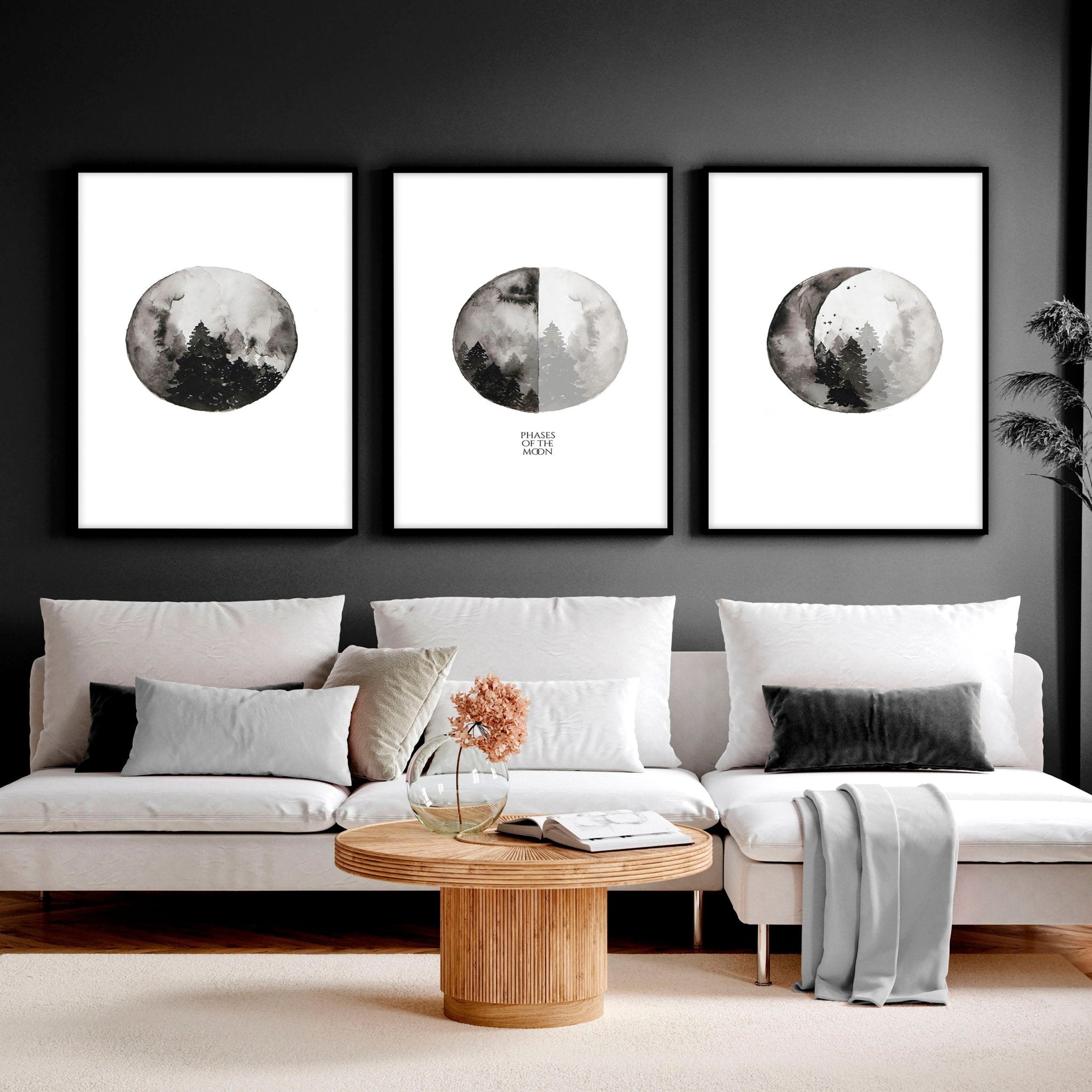 Set of 3 framed wall art prints depicting the phases of the moon in a monochromatic design, perfect for enhancing living room decor.