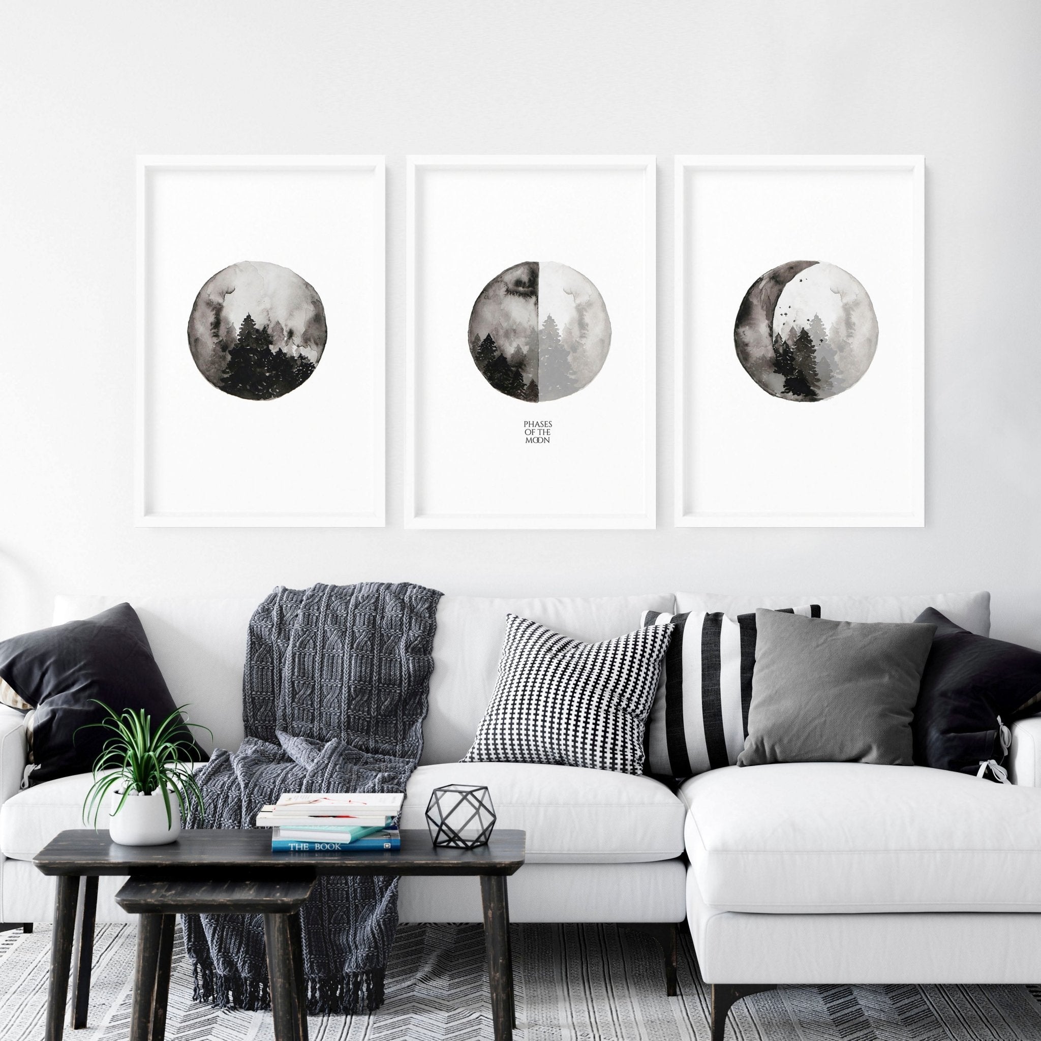 Set of 3 framed wall art prints depicting the phases of the moon in a monochromatic design, perfect for enhancing living room decor.