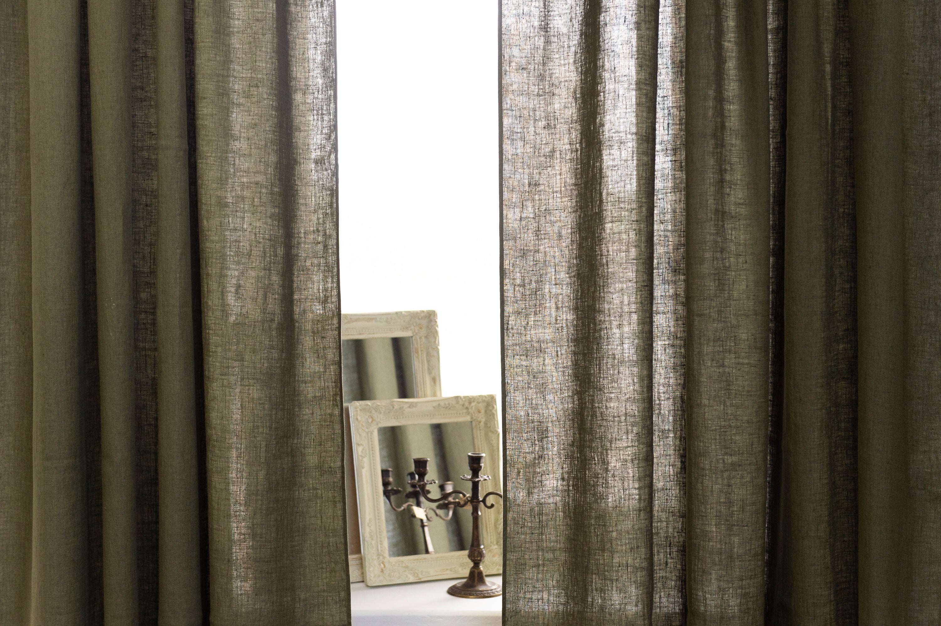 Moss green linen curtain with rod pocket, showcasing its semi-sheer texture and elegant color.