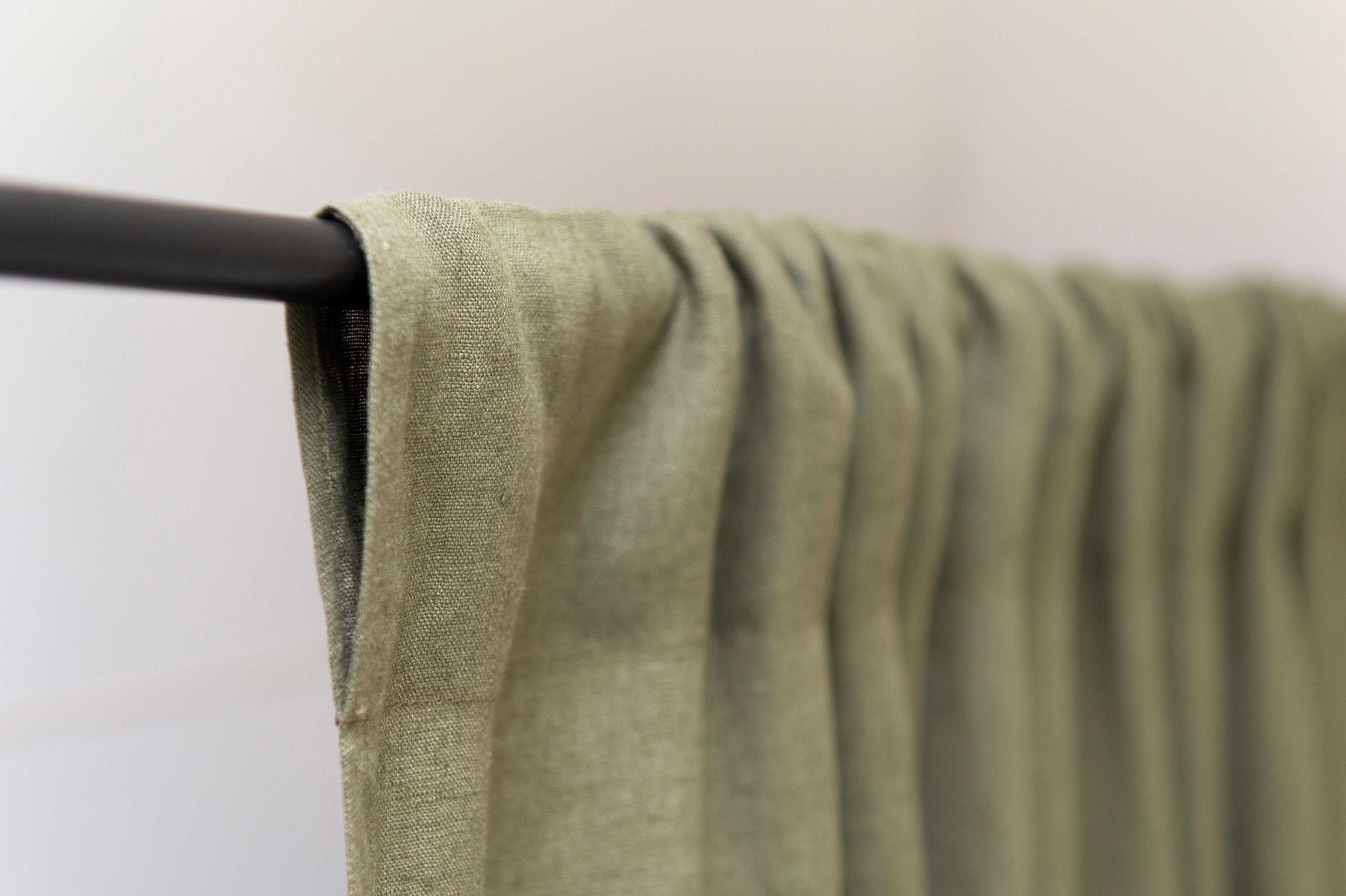 Moss green linen curtain with rod pocket, showcasing its semi-sheer texture and elegant color.