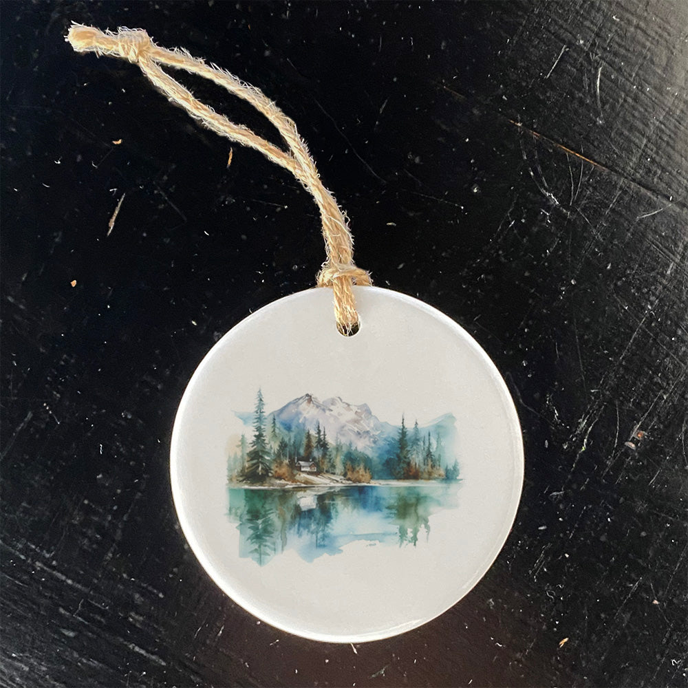 A beautifully crafted porcelain ornament featuring a serene mountains and lake design, perfect for holiday decor or gifting.