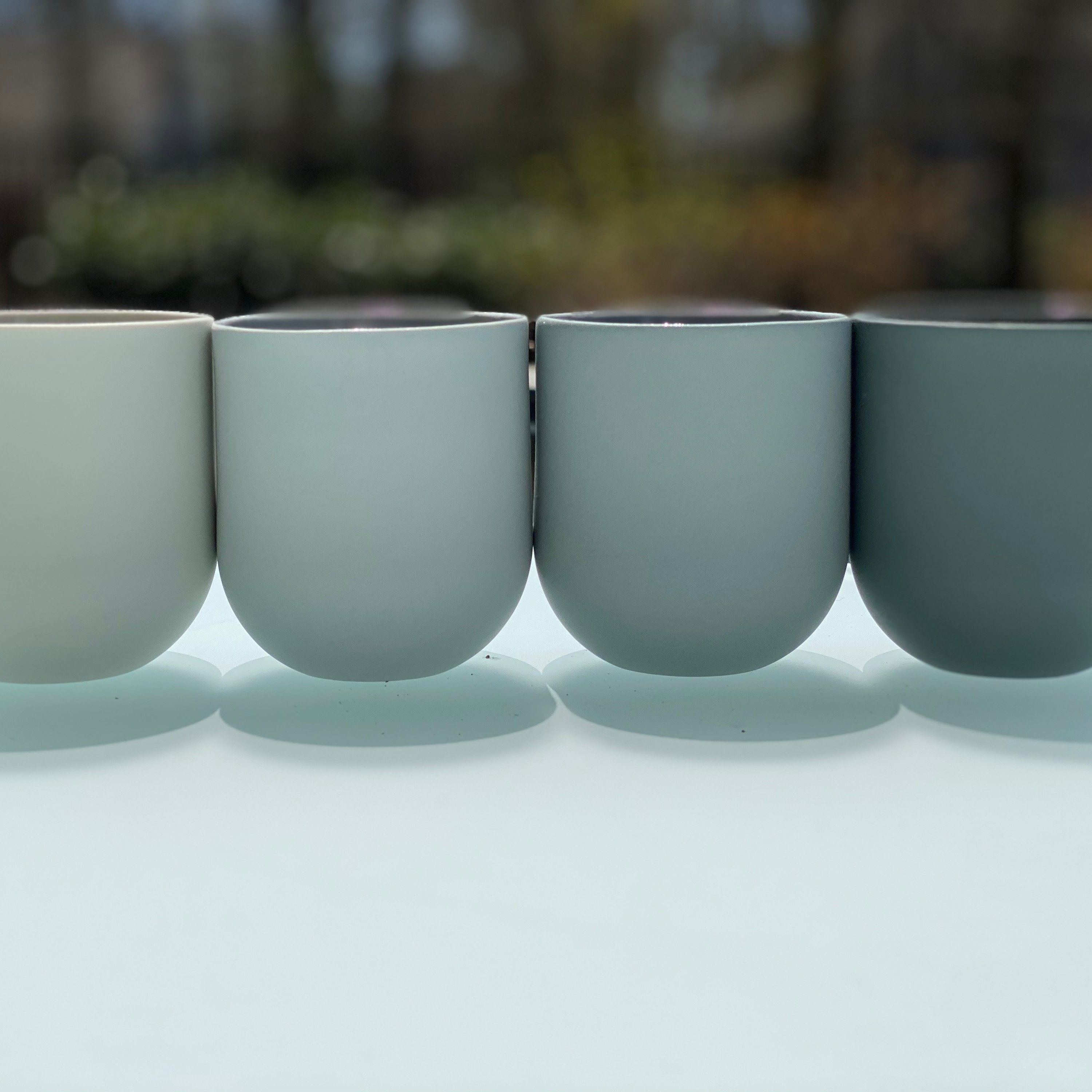 Set of 4 SUM GRADIENT mugs in blue and grey, showcasing smooth glazed interiors and raw matte exteriors, perfect for stylish coffee enjoyment.