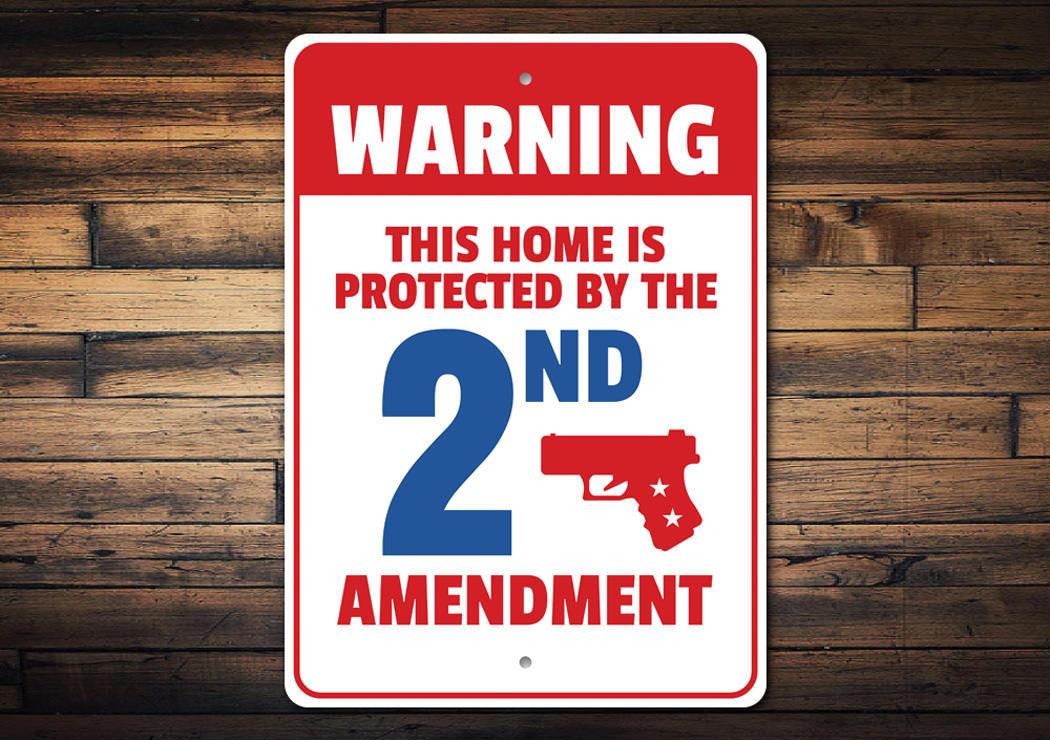 A decorative warning sign stating 'My Home is Protected by the 2nd Amendment', made of durable aluminum, featuring pre-drilled holes for easy mounting.