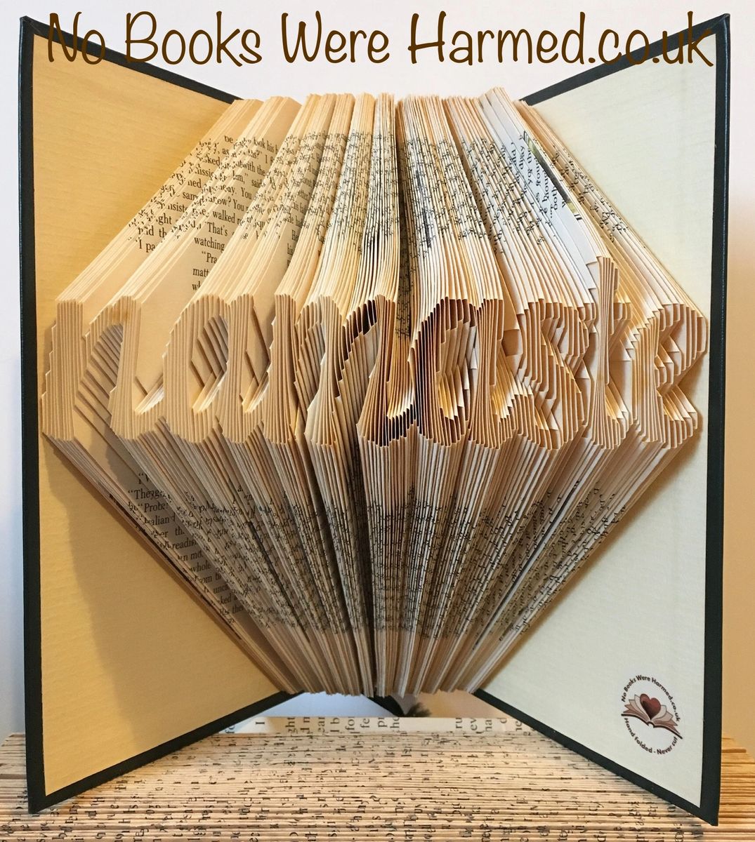 Hand-folded book art titled Namaste, crafted from vintage books, showcasing unique designs and textures.