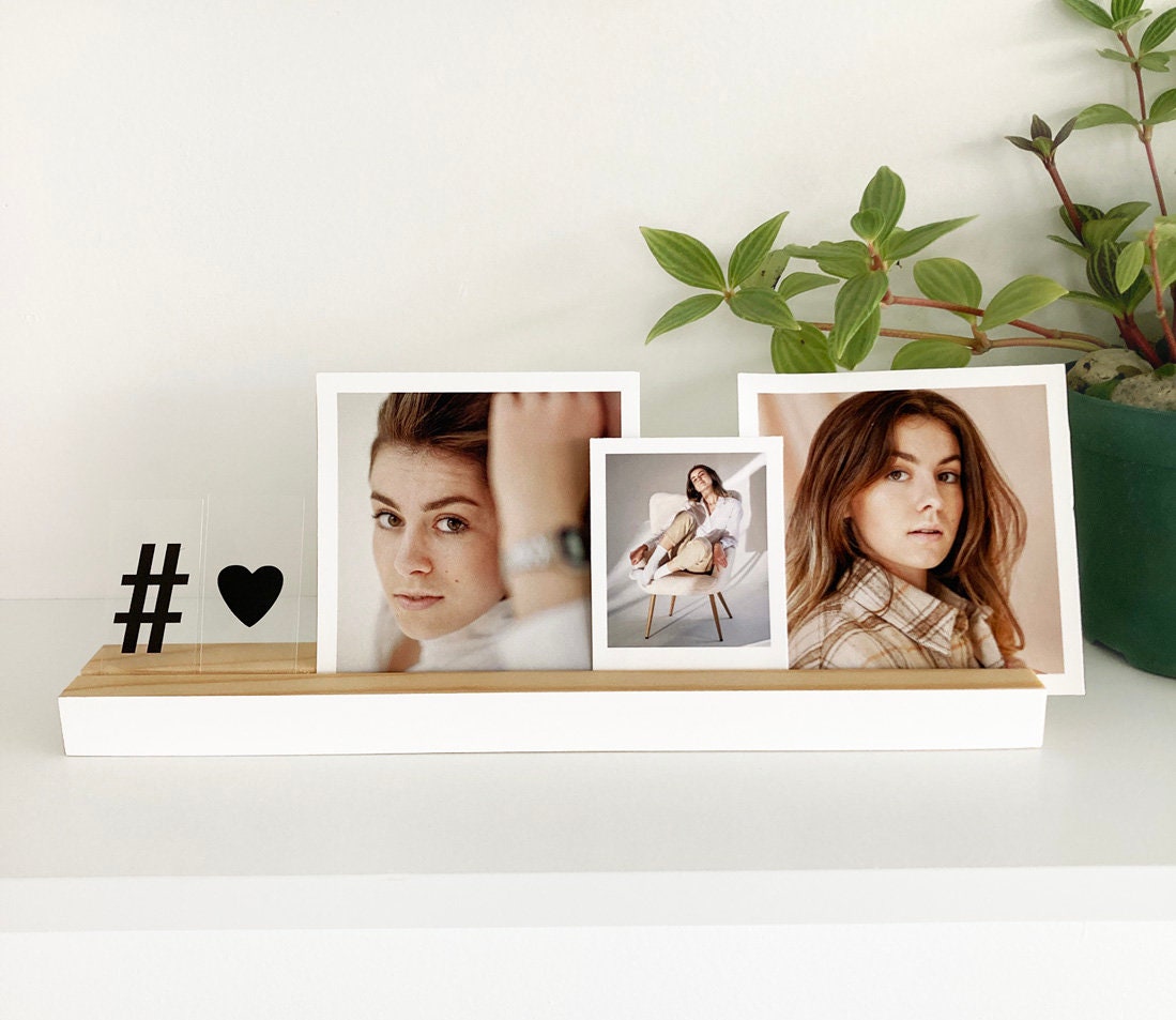 Natural wooden photo ledge displaying various photos and art prints, showcasing its elegant design and eco-friendly material.