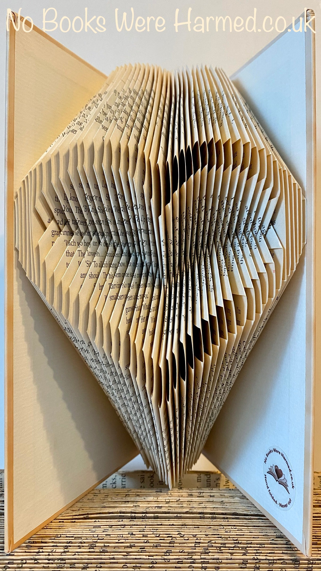 Handcrafted Open Heart art piece made from vintage book pages, showcasing intricate folds and unique design.