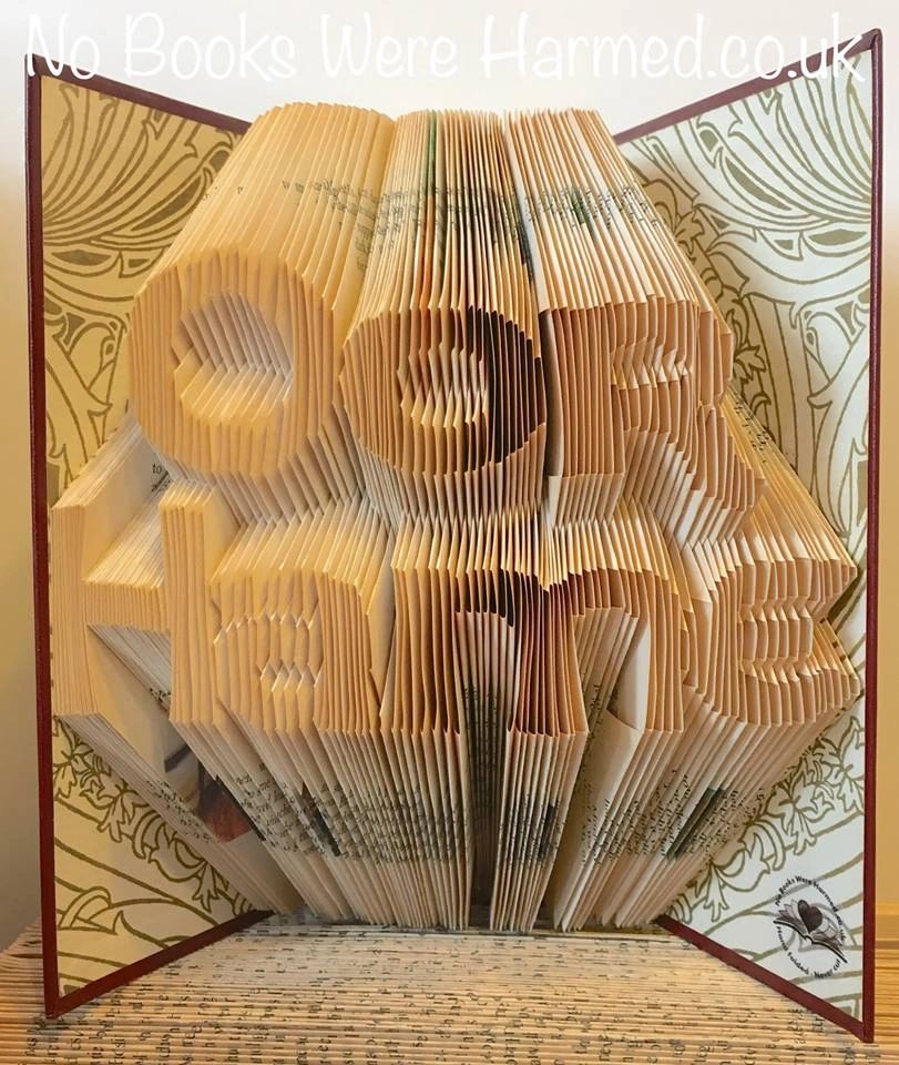 Handcrafted book art piece made from vintage books, showcasing intricate hand-folded pages in unique designs.