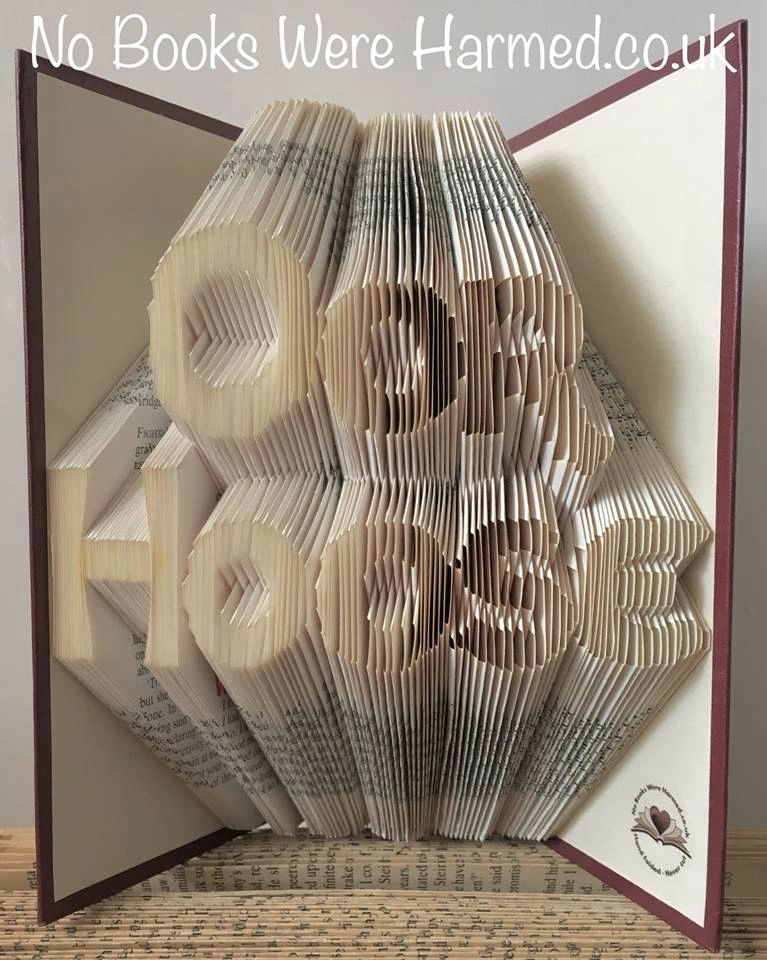 Handcrafted book art piece made from vintage books, showcasing intricate page folds and unique design.