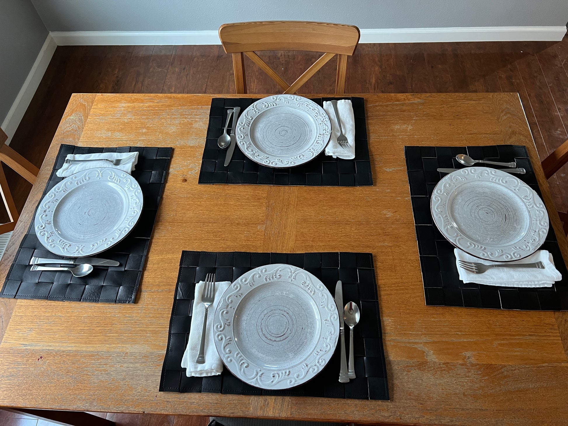 A set of four handmade leather placemats made from premium cowhide, showcasing a rustic and elegant design.