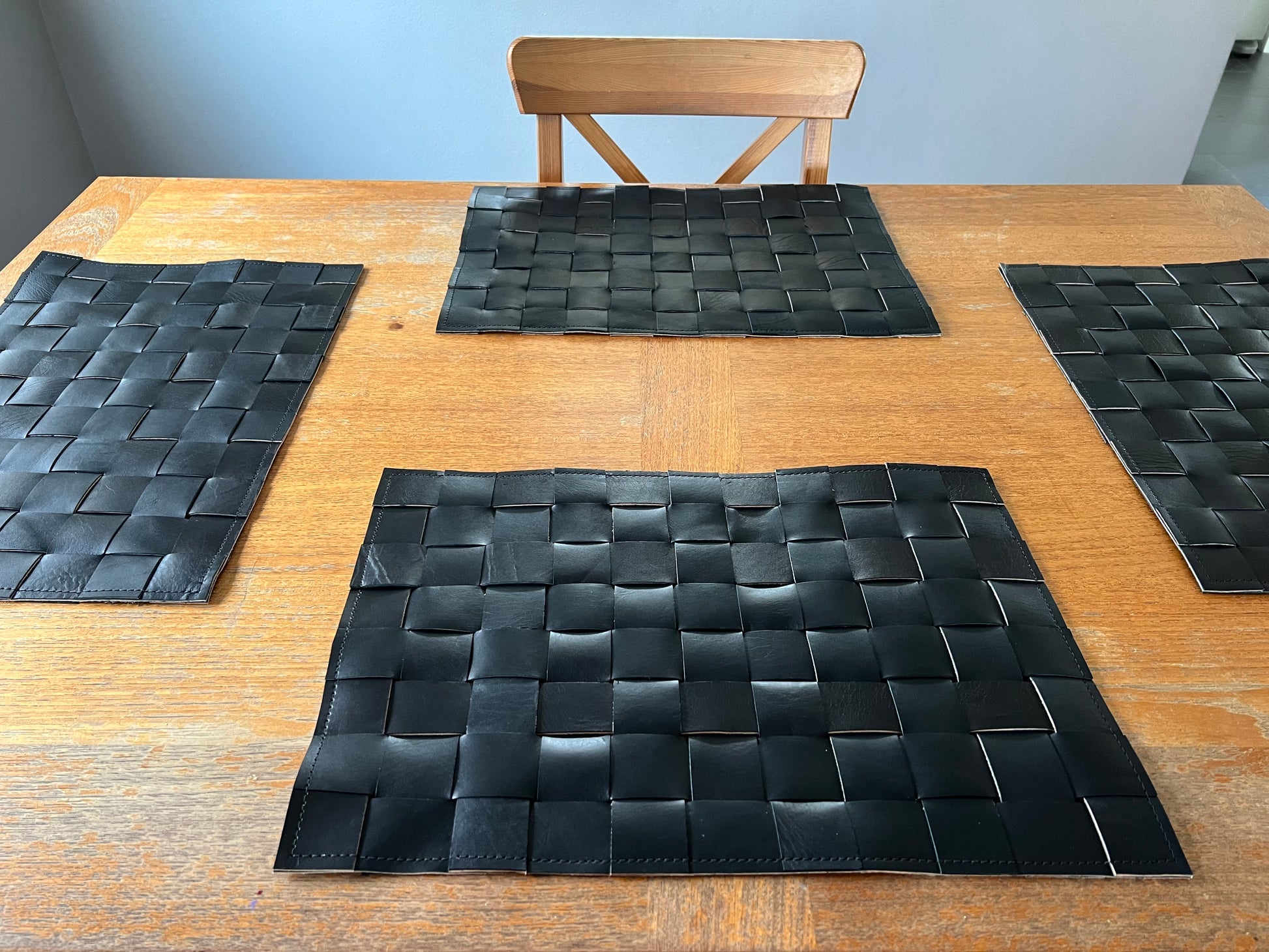 A set of four handmade leather placemats made from premium cowhide, showcasing a rustic and elegant design.